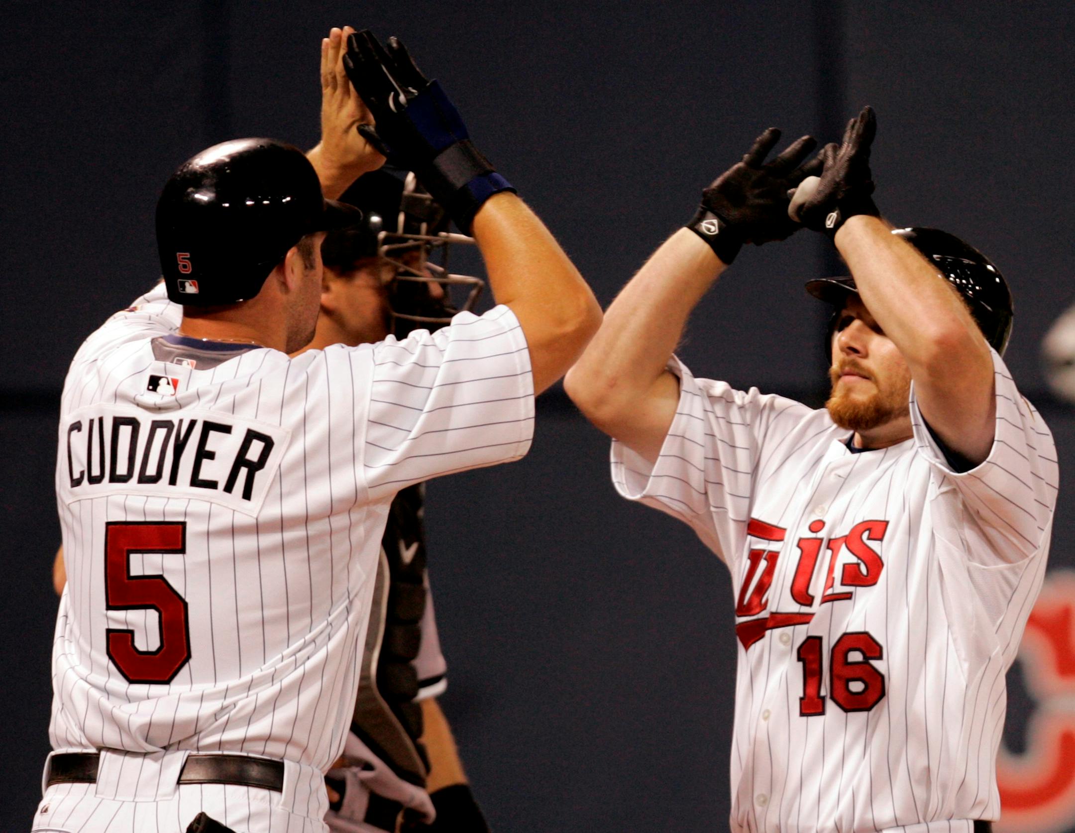 Twins Jason Kubel (16) was greeted by teammate Michael Cuddyer (5) at home plate after hitting a two-run homerun in the fourth inning.