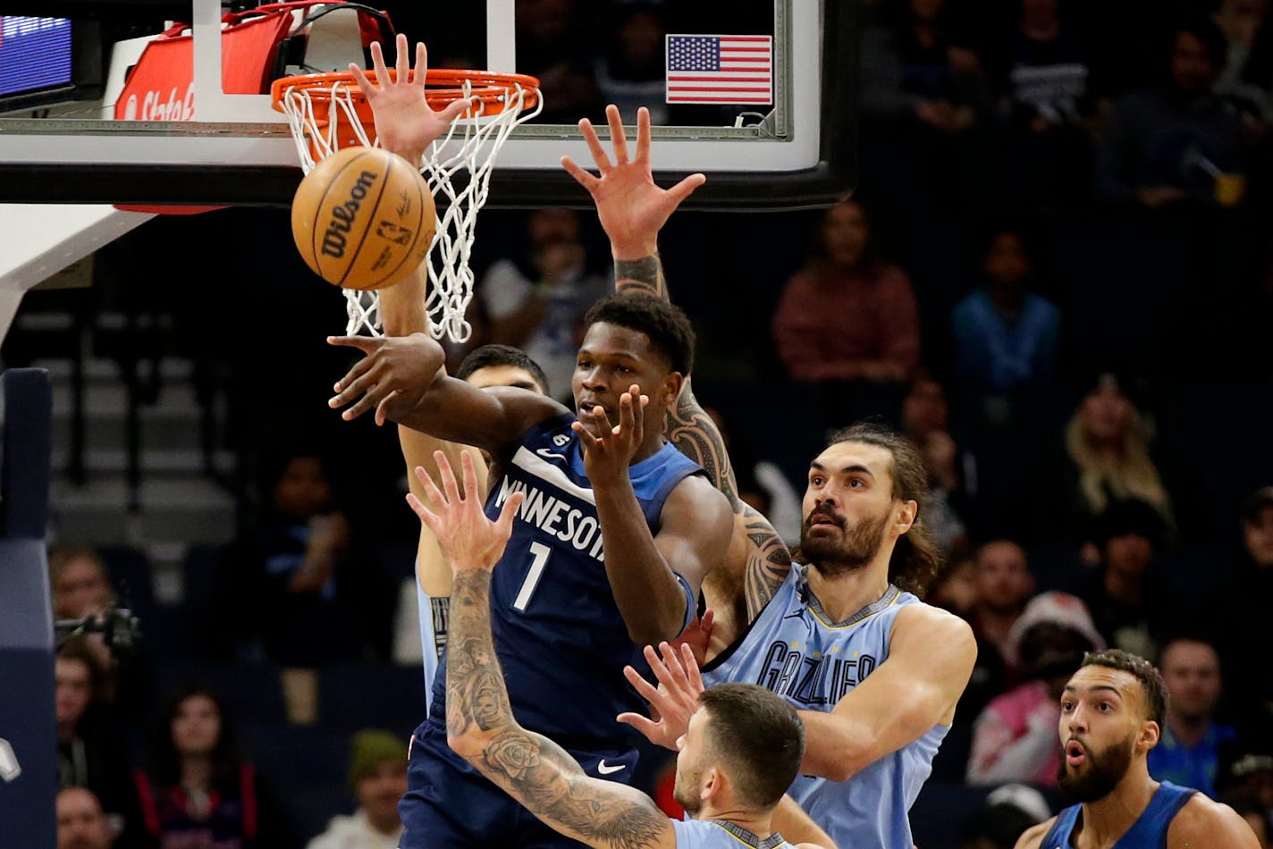 Minnesota Timberwolves guard Anthony Edwards (1) passes under pressure from Memphis Grizzlies center Anthony Edwards (4) in the first quarter of an NBA basketball game Wednesday, Nov. 30, 2022, in Minneapolis. (AP Photo/Andy Clayton-King)