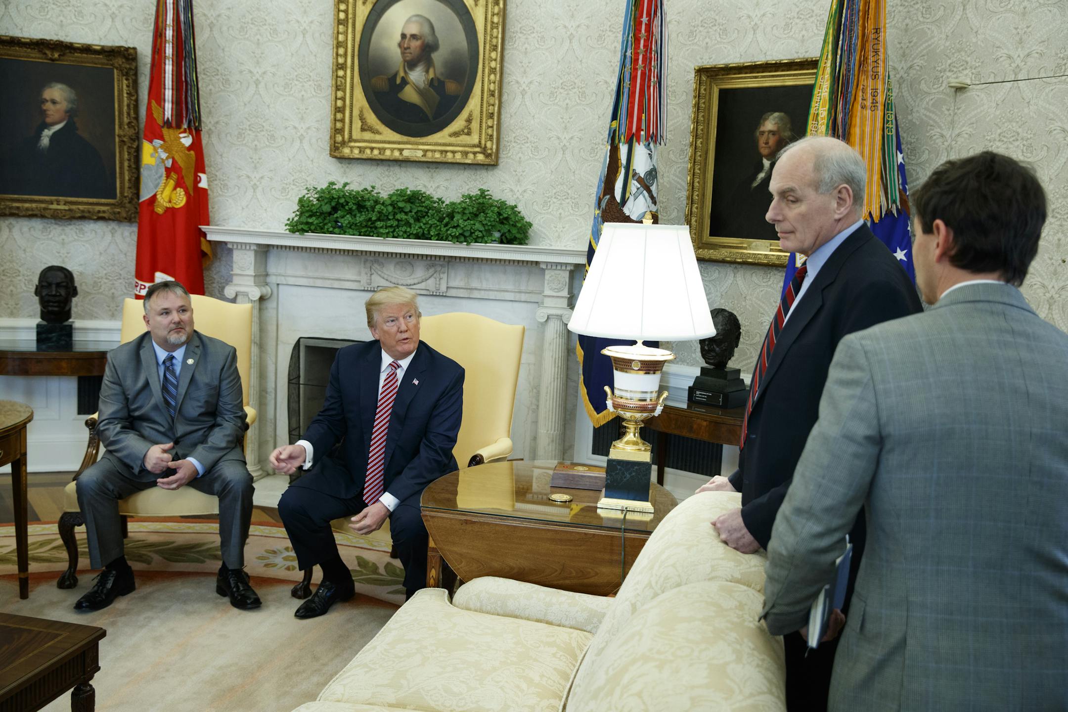 President Donald Trump speaks with White House Chief of Staff John Kelly, second from right, and White House deputy press secretary Hogan Gidley, right, after meeting with Don Bouvet, left, in the Oval Office of the White House, Friday, Feb. 9, 2018, in Washington.