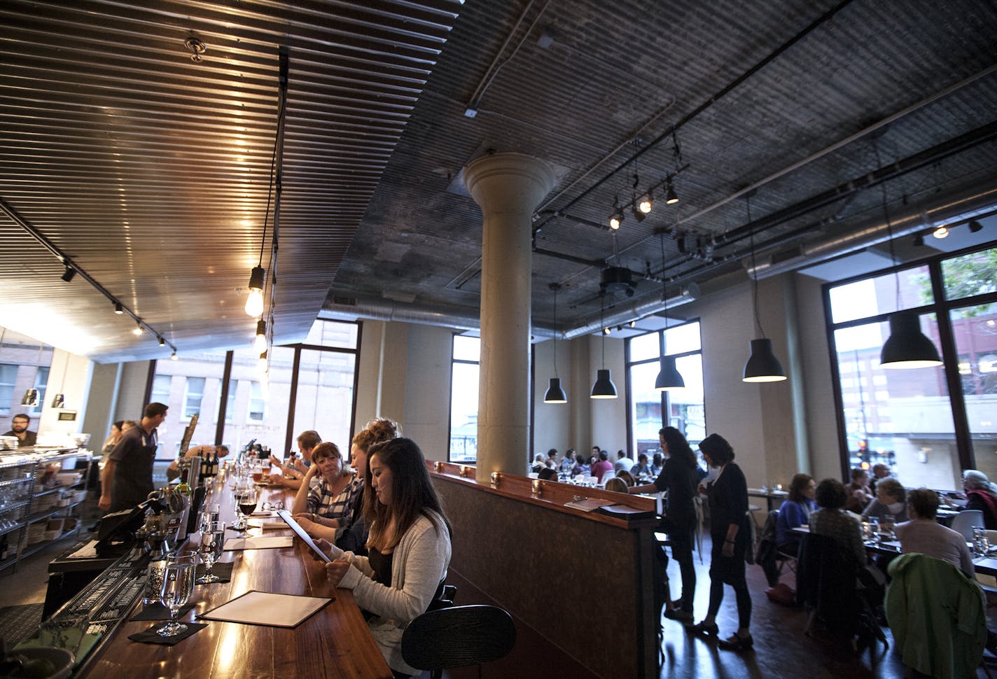 A dramatic, corrugated steel canopy hangs over the Brazilian walnut-topped bar/kitchen counter at Saint Dinette in Lowertown&#x2019;s Rayette Lofts.