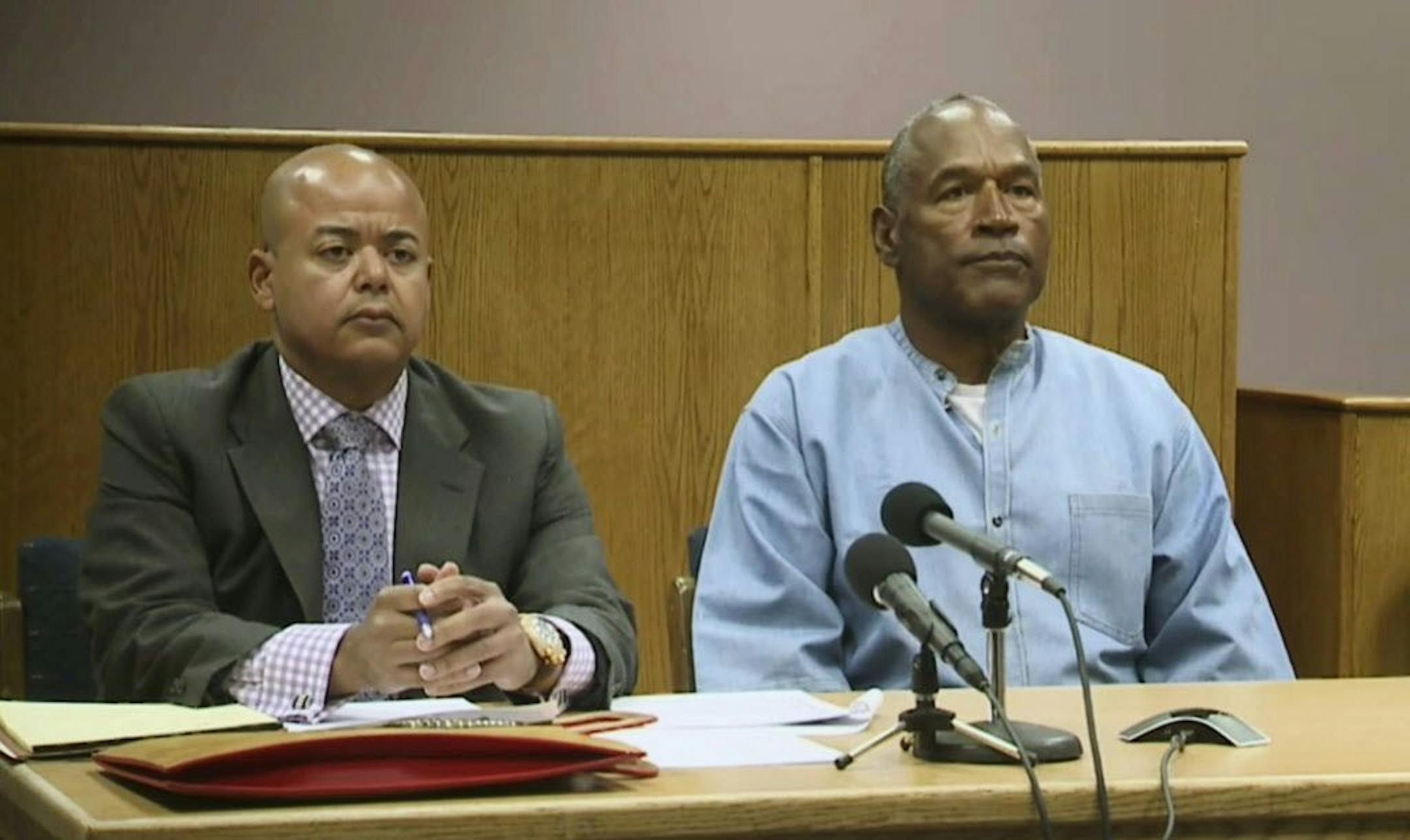 Former NFL football star O.J. Simpson appears with his attorney, Malcolm LaVergne, left, via video for his parole hearing at the Lovelock Correctional Center in Lovelock, Nev., on Thursday, July 20, 2017. Simpson was convicted in 2008 of enlisting some men he barely knew, including two who had guns, to retrieve from two sports collectibles sellers some items that Simpson said were stolen from him a decade earlier.