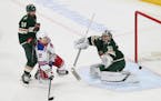 The Wild's Alex Stalock, right, blocks a shot as New York Rangers' Jesper Fast, second from left, looks for a rebound during the first period