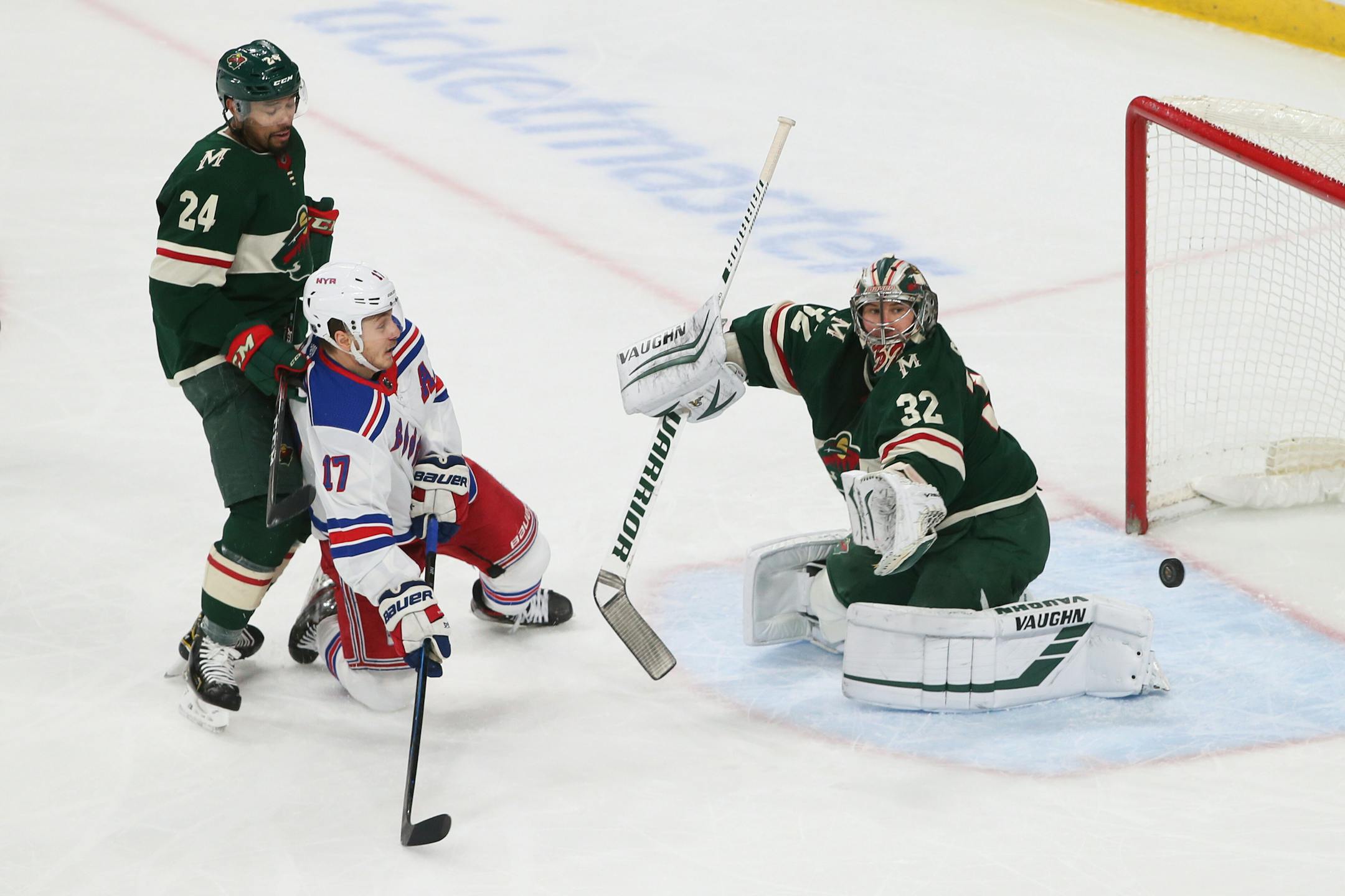 The Wild's Alex Stalock, right, blocks a shot as New York Rangers' Jesper Fast, second from left, looks for a rebound during the first period