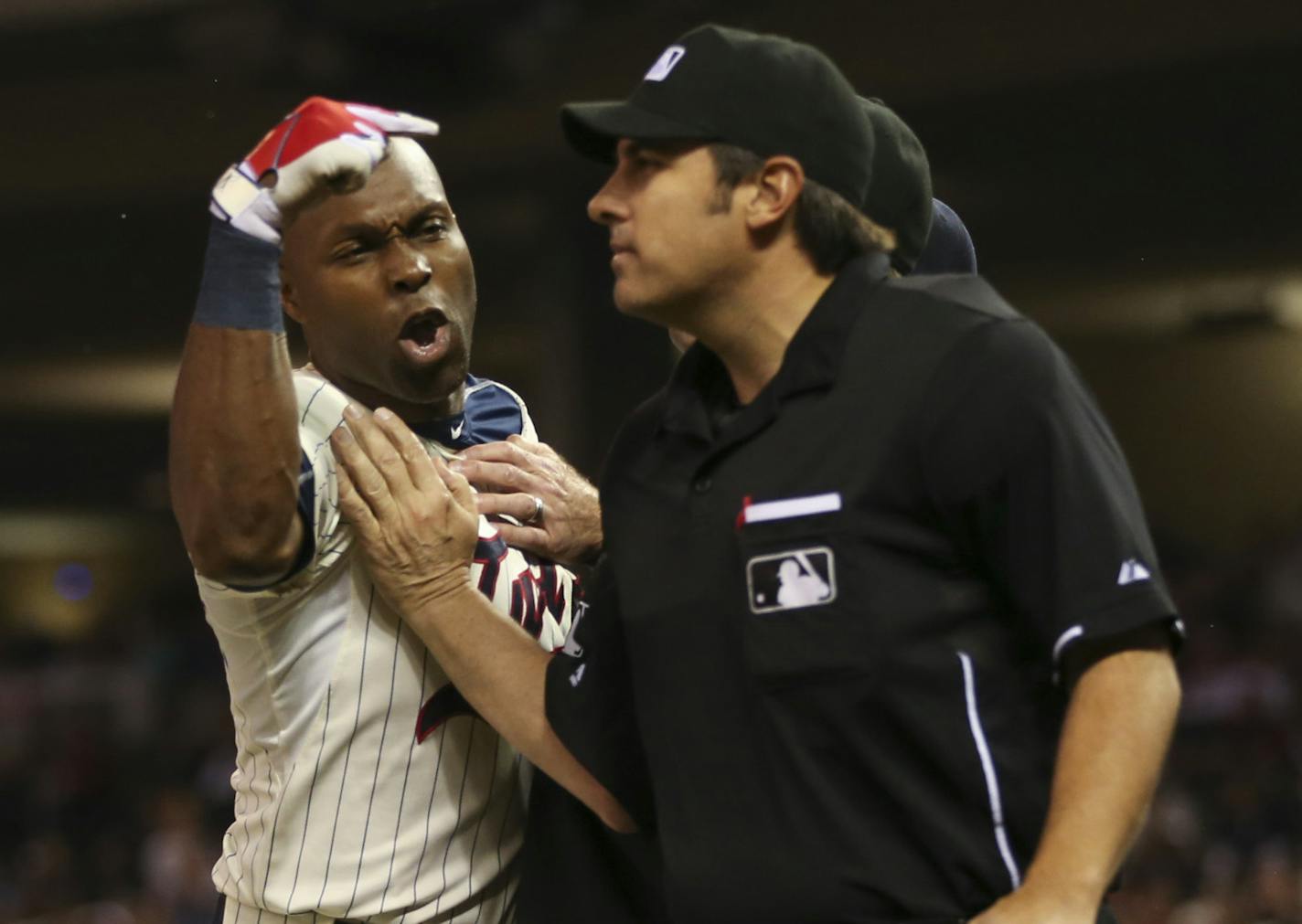 First base umpire Jeff Kellogg, obscured, restrained the Twins' Torii Hunter as he yelled at home plate umpire Mark Ripperger, right, after he ejected Hunter for arguing a called third strike in the eighth inning Wednesday night at Target Field.