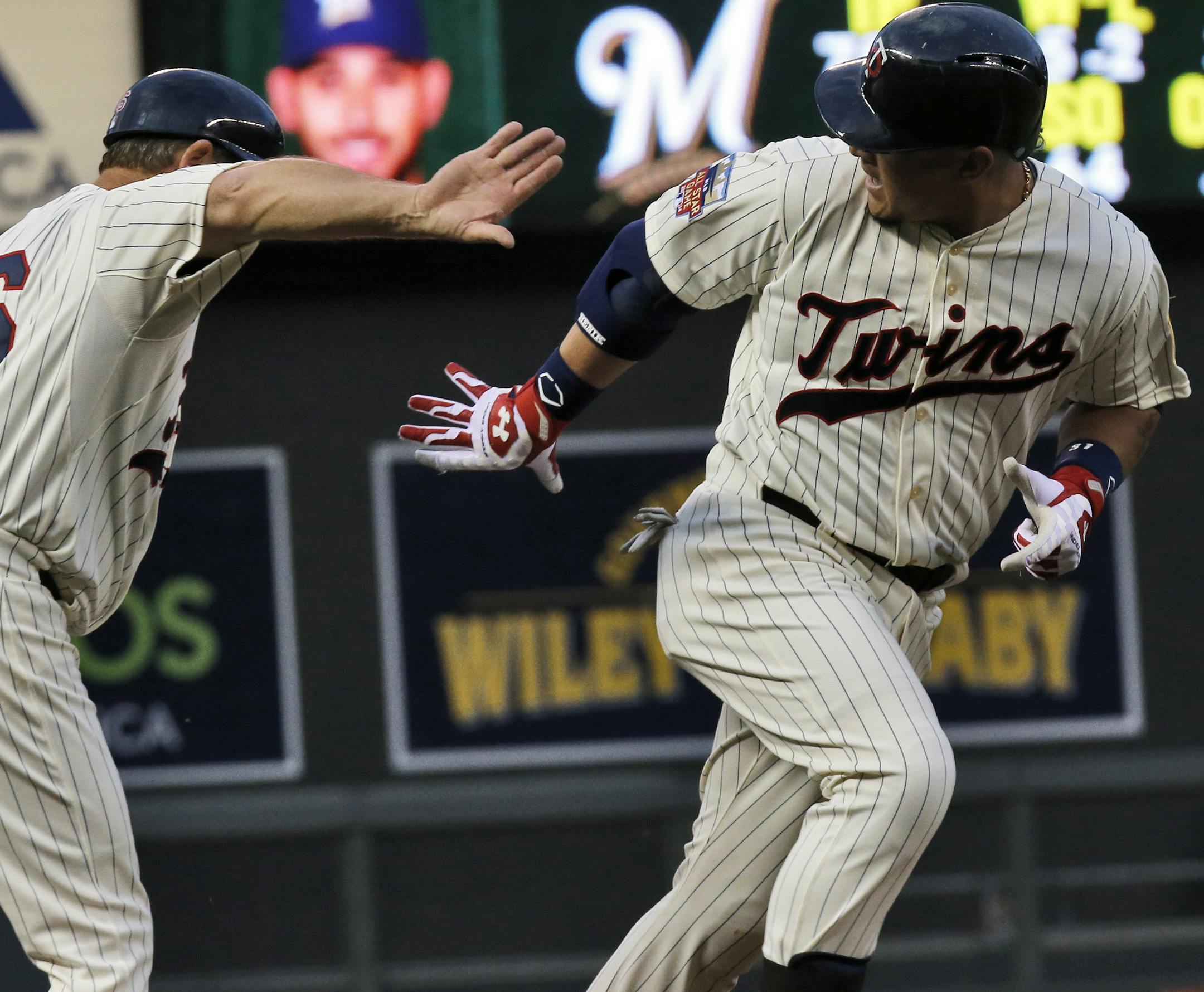 Twins 3rd base coach Joe Vavra congratulated Oswaldo Arcia after he hit a three-run home run in the 4th inning.