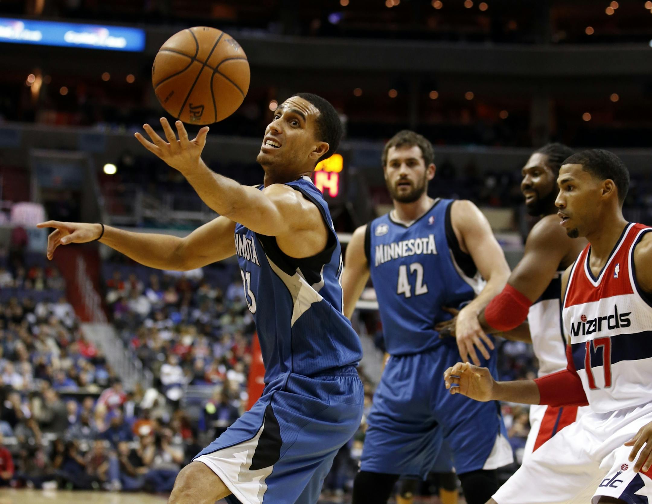 Minnesota Timberwolves guard Kevin Martin (23) grabs the loose ball in front of Washington Wizards guard Garrett Temple (17), with Timberwolves forward Kevin Love (42) behind, in the first half of an NBA basketball game Tuesday, Nov. 19, 2013, in Washington.