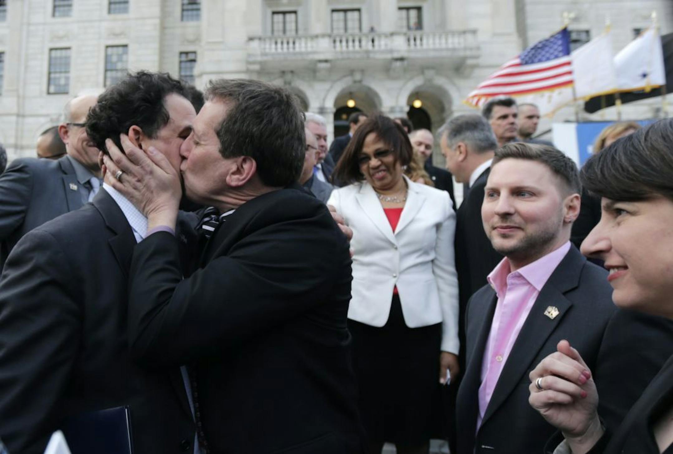 Rhode Island House Speaker Gordon Fox, left, is kissed by R.I. Rep. Frank Ferri, D-Warwick, after a gay marriage bill was signed into law outside the State House in Providence, R.I., Thursday, May 2, 2013.
