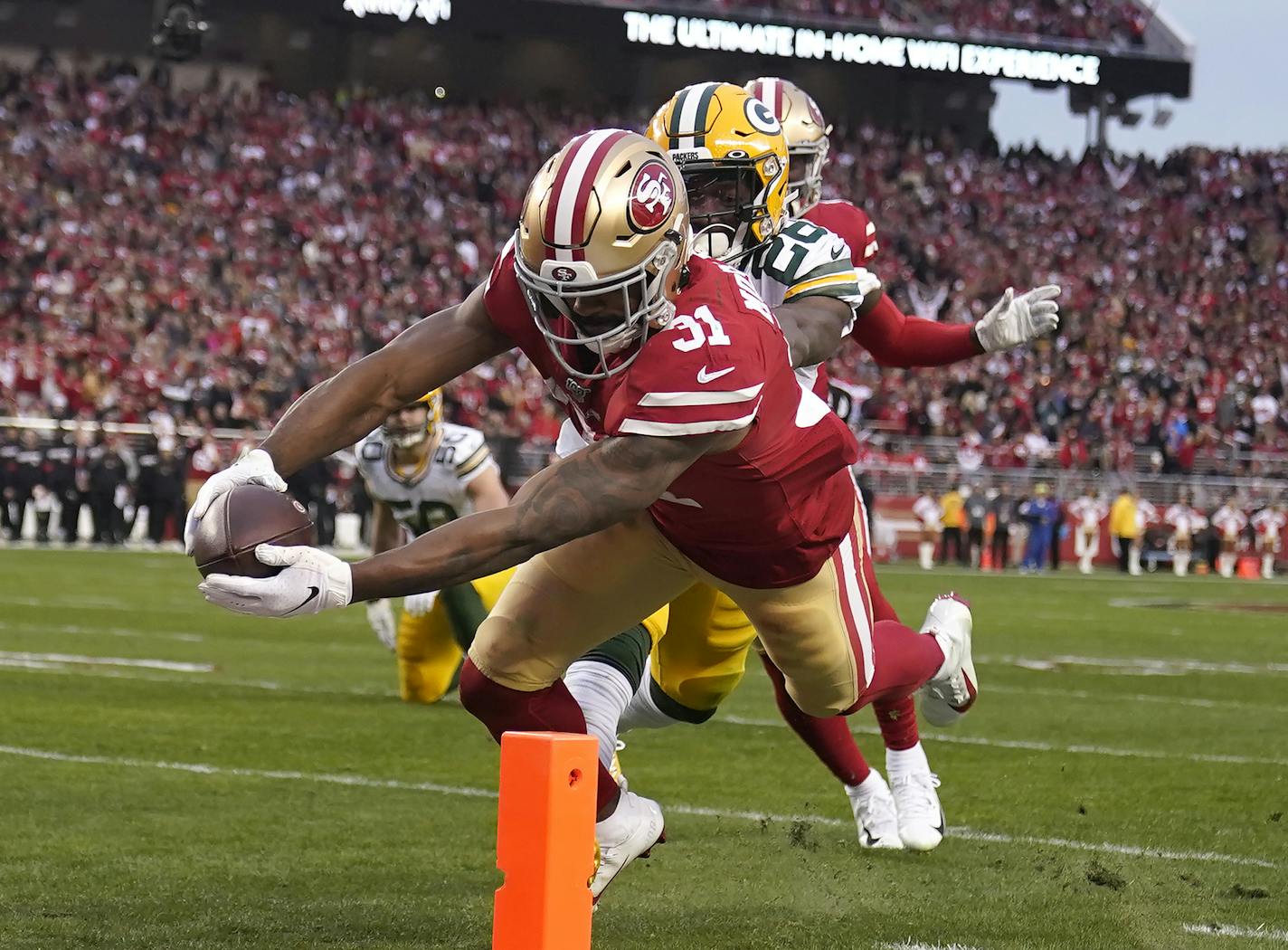 San Francisco running back Raheem Mostert scores in front of Green Bay free safety Darnell Savage during the first half of the NFC Championship Game