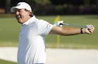 Phil Mickelson stretches before hitting on the driving range during a practice round for the Masters golf tournament Wednesday, April 6, 2016, in Augu