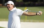 Phil Mickelson stretches before hitting on the driving range during a practice round for the Masters golf tournament Wednesday, April 6, 2016, in Augu