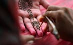 Niveditha Sreekantan, 15, of Edina got her hands pained with Henna during IndiaFest Saturday.