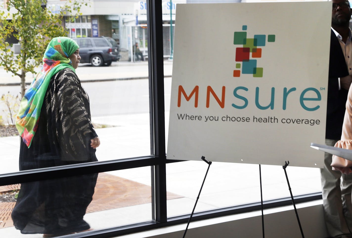 In this Oct. 26, 2017, photo, a woman walks past an enrollment office for MNsure, (AP Photo/Jim Mone) ORG XMIT: MIN2017103117540497 ORG XMIT: MIN1907091517487004 ORG XMIT: MIN2006241344413175