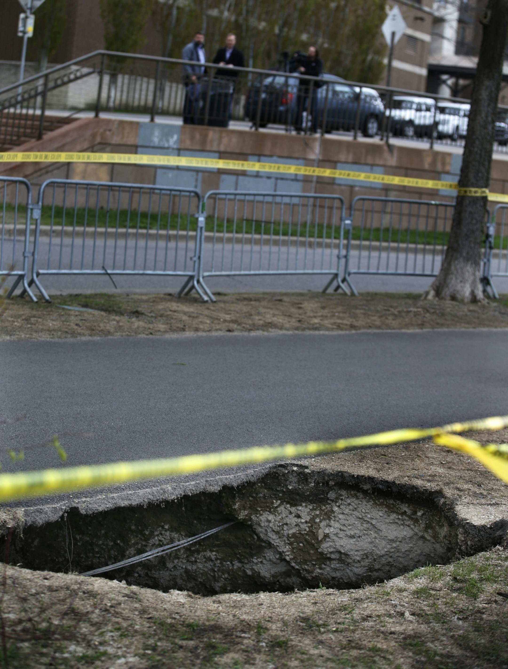 On the bike path of the W. River Parkway near Portland Ave and the Stone Arch Bridge where a sinkhole developed, authorities close traffic as a precaution.