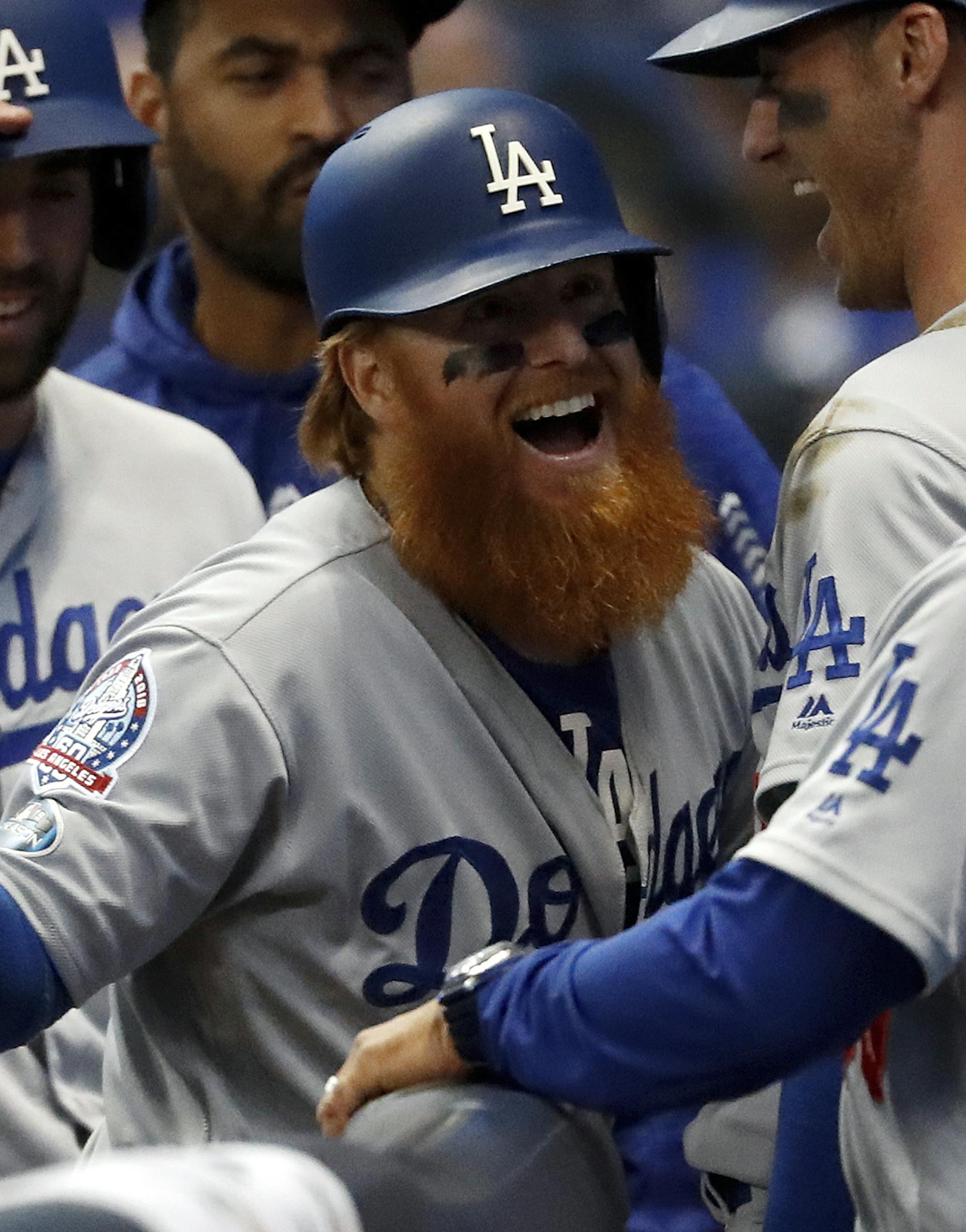 Los Angeles Dodgers' Justin Turner (10) celebrates with manager Dave Roberts (30) after hitting a two-run home run during the eighth inning of Game 2 of the National League Championship Series baseball game against the Milwaukee Brewers Saturday, Oct. 13, 2018, in Milwaukee. (AP Photo/Jeff Roberson)