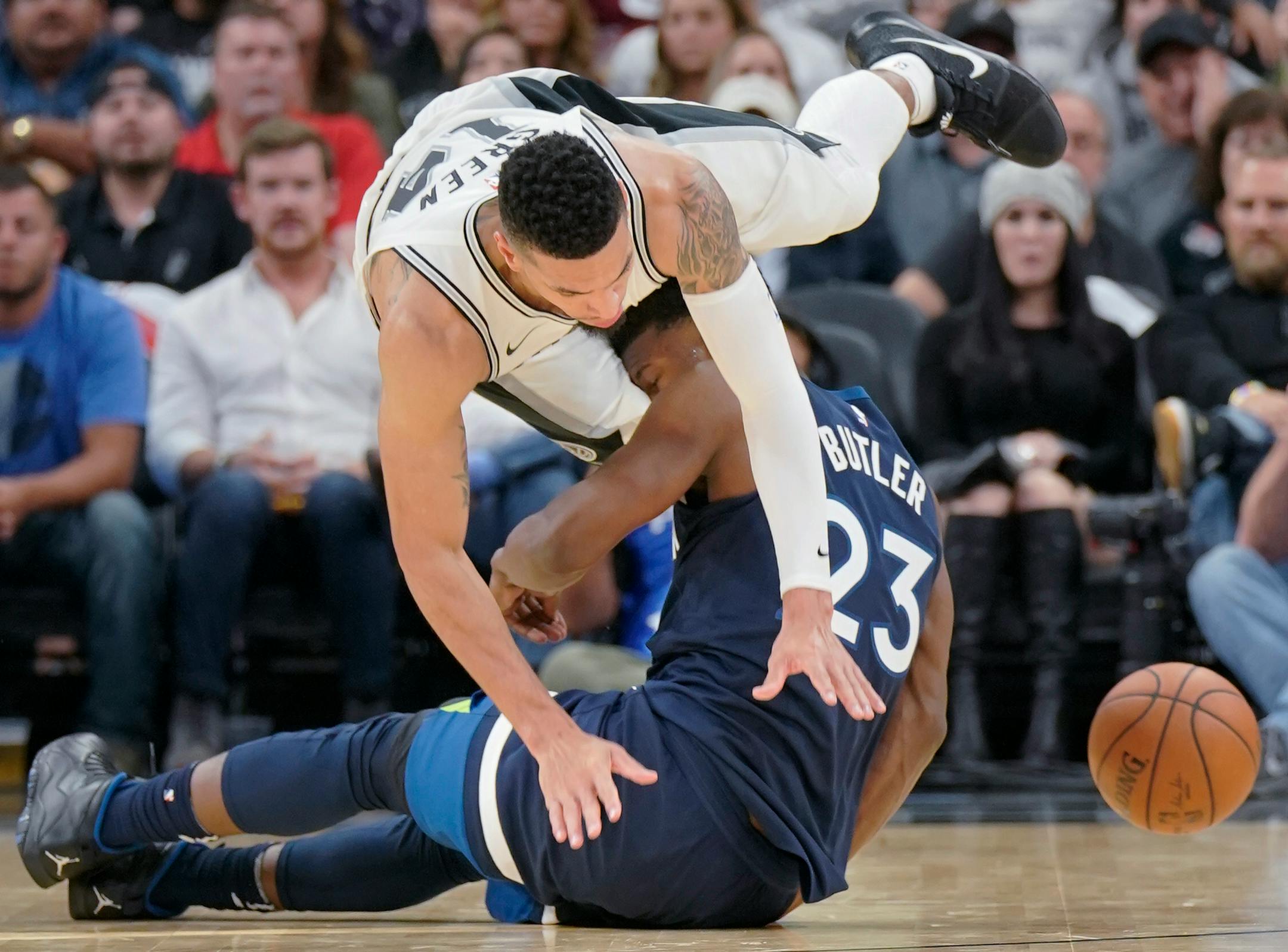 San Antonio Spurs' Danny Green collides with Minnesota Timberwolves' Jimmy Butler (23) during the second half of an NBA basketball game, Wednesday, Oct. 18, 2017, in San Antonio. San Antonio won 107-99. (AP Photo/Darren Abate)