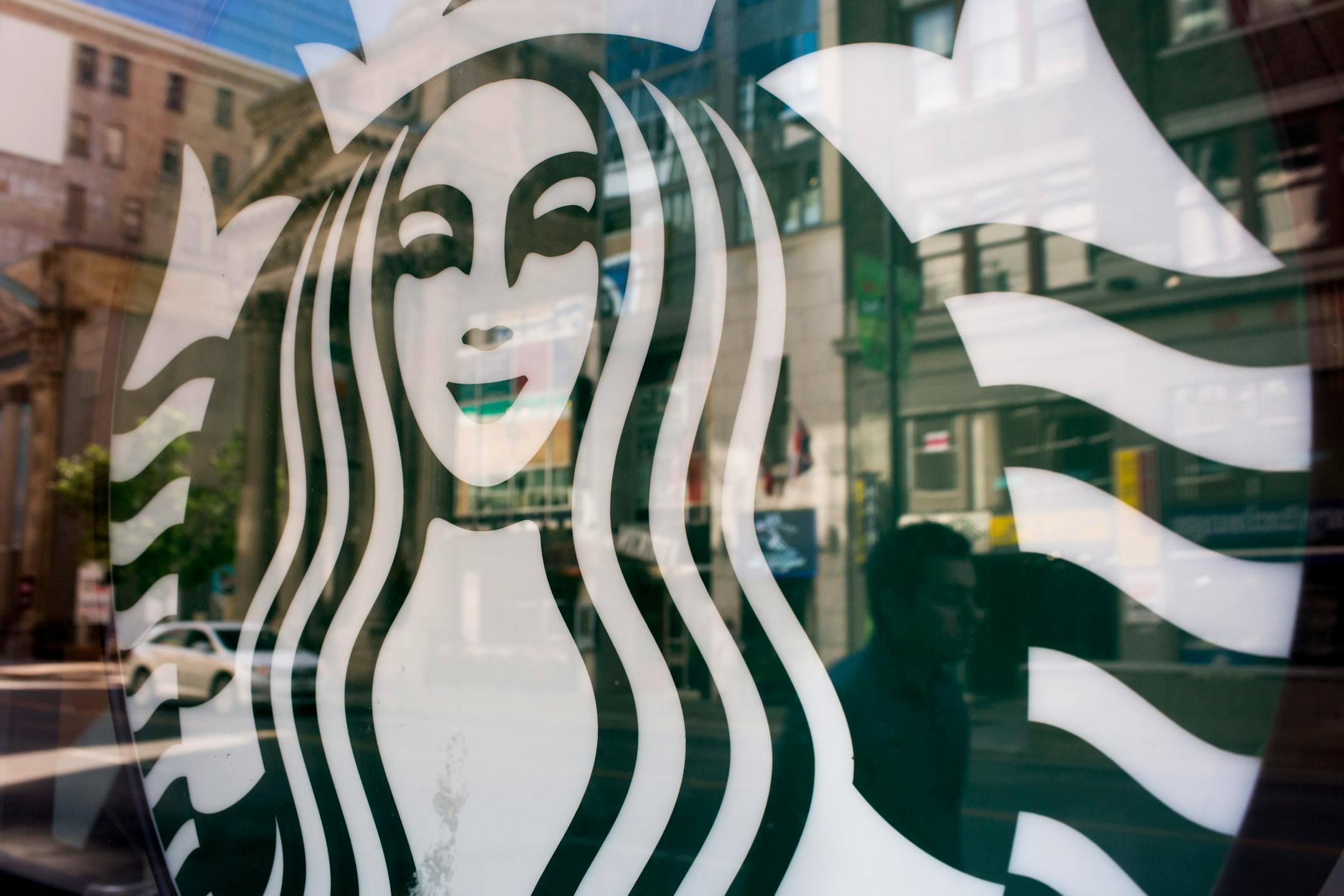 Starbucks Corp. logo seen in the window of a store in Toronto, Ontario, Canada, on Tuesday, July 23, 2013.
