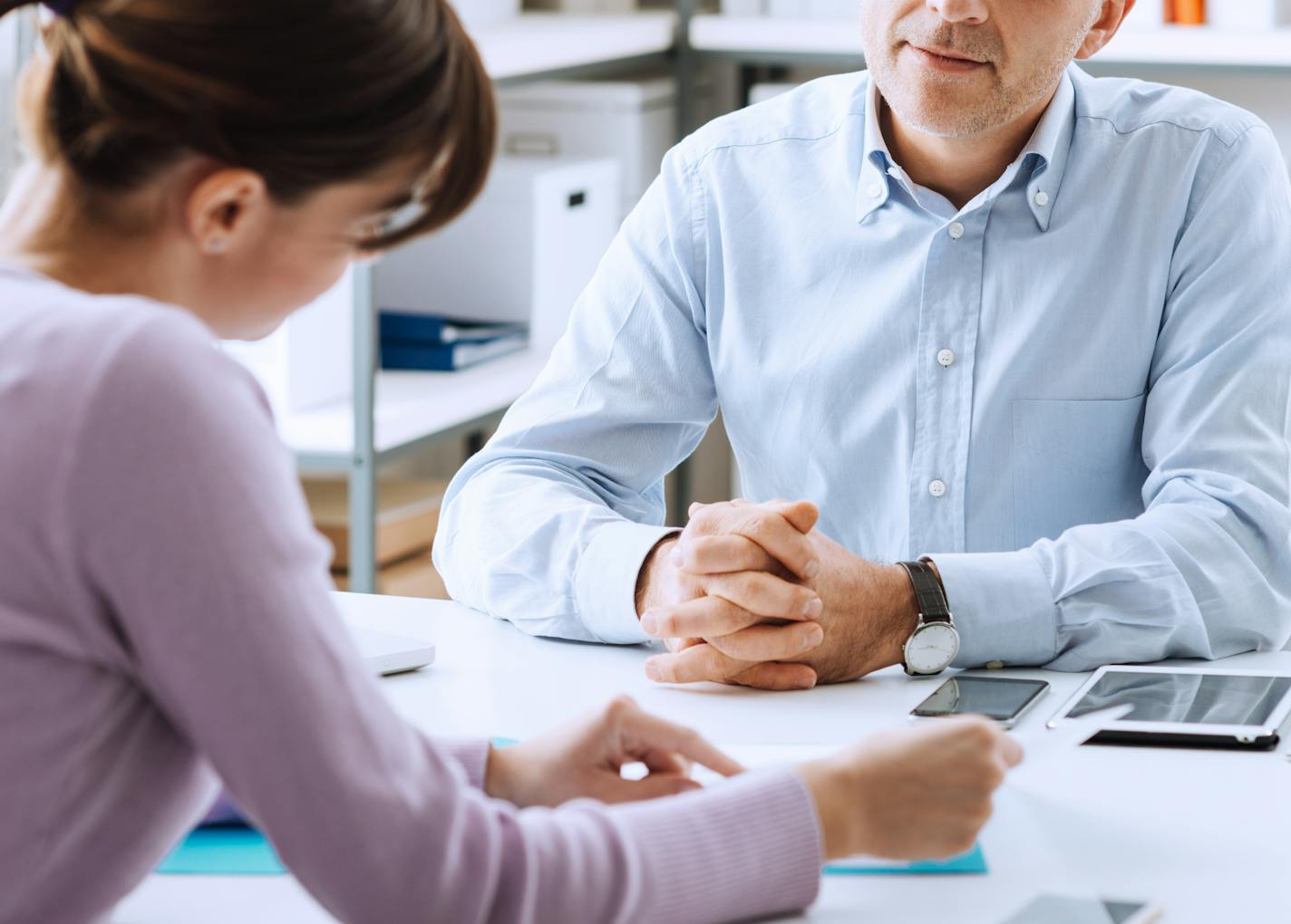 Mature businessman and young woman having a business meeting in the office, they are discussing together