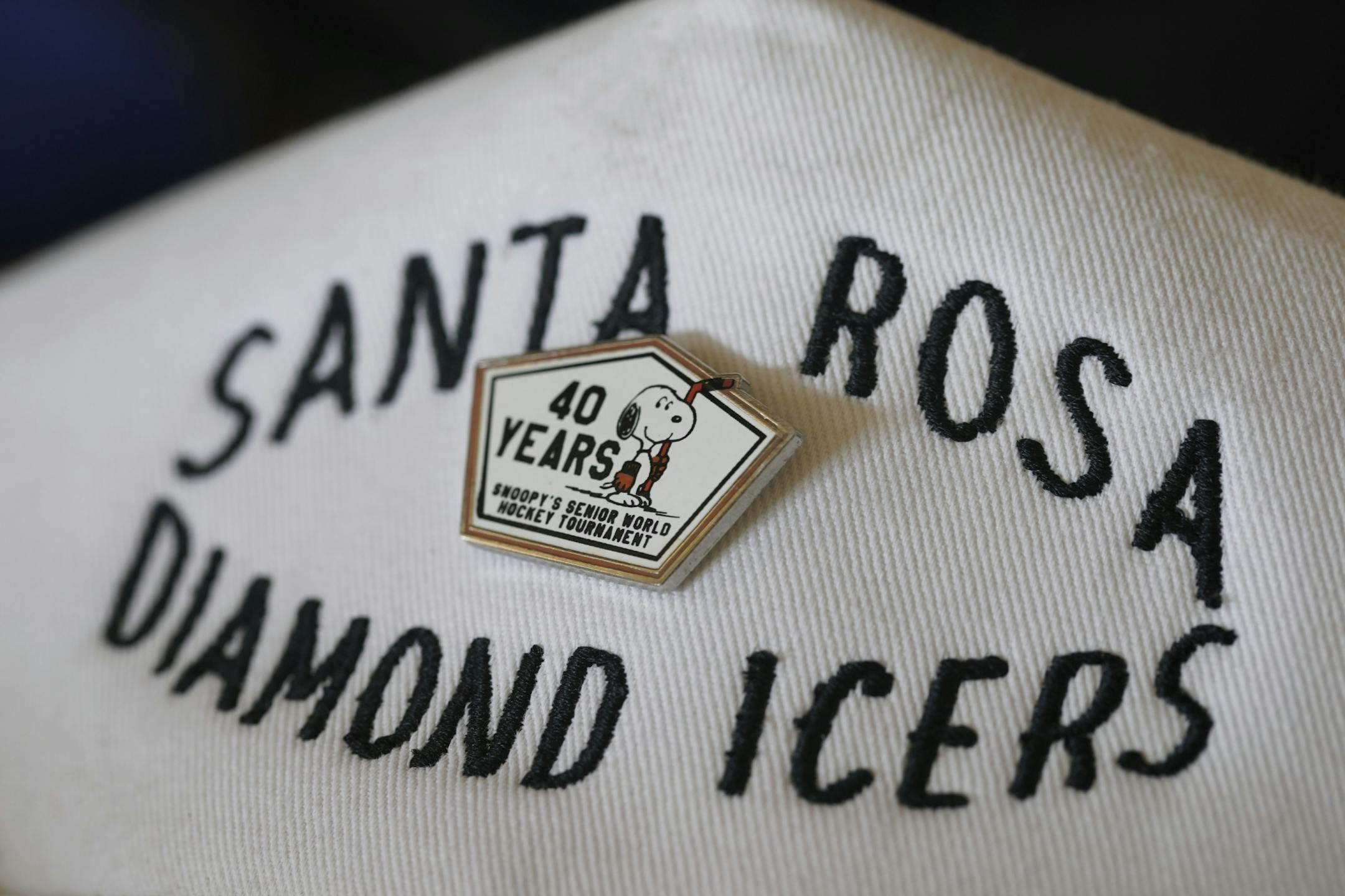 A commemorative pin from the 40th Snoopy's Senior World Hockey Tournament that Mark Sertich participated in. He has it on a cap he wears daily.