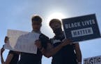 Gophers football players Brevyn Spann-Ford (left) and Seth Green held signs at the protest on the I-35W bridge Sunday in Minneapolis.