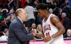 Minnesota Timberwolves head coach Tom Thibodeau, left, shakes hands with his former player Chicago Bulls' Jimmy Butler after an NBA basketball game Tu