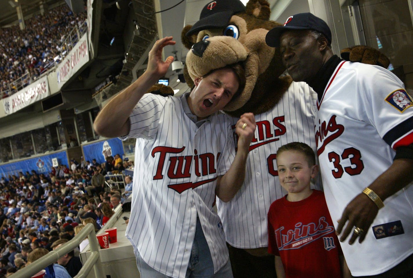 Showing his ever-present sense of humor, Governor Tim Pawlenty, left, jokes with the Twins mascot before singing during the seventh inning stretch on opening day of the 2003 Twins baseball season. Joining the governor were ten-year-old Jonas Layer of North Branch, MN, center, and former Twin Jim "Mudcat" Grant, right, who pitched the Twins into the 1965 World Series. GENERAL INFORMATION: 4/4/03- Spending the day with Governor Tim Pawlenty for a story on his first 100 days.