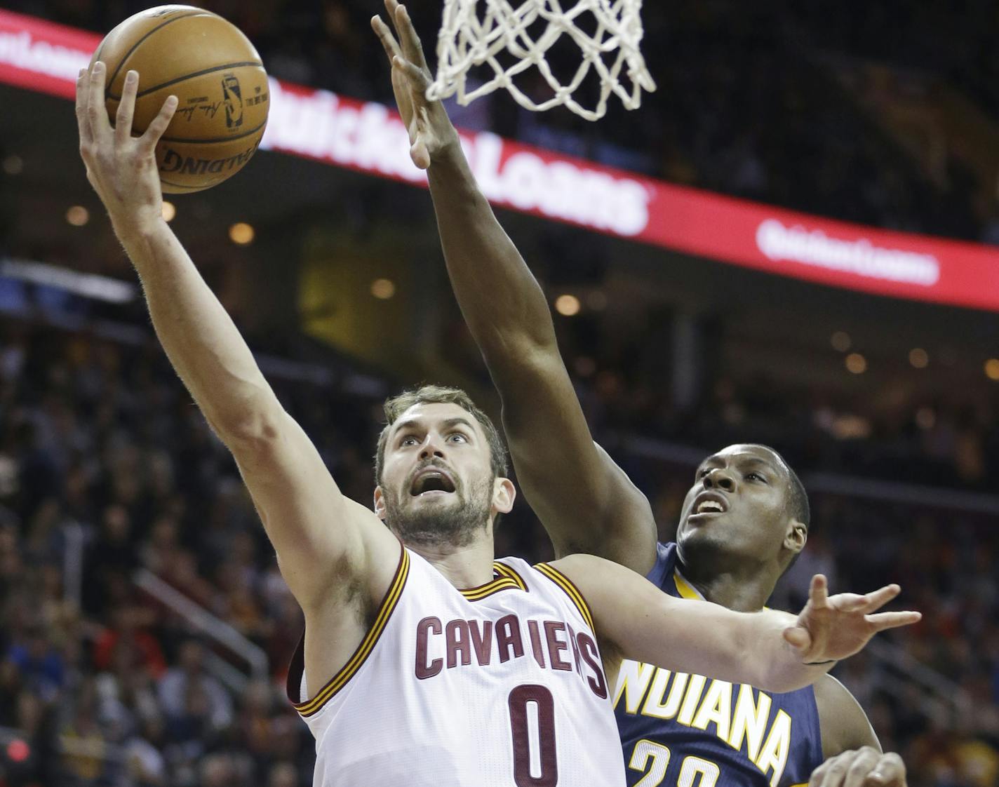 Cleveland Cavaliers' Kevin Love (0) drives to the basket against Indiana Pacers' Ian Mahinmi (28), from France, during the first quarter of an NBA basketball game Saturday, Nov. 29, 2014, in Cleveland. (AP Photo/Tony Dejak)