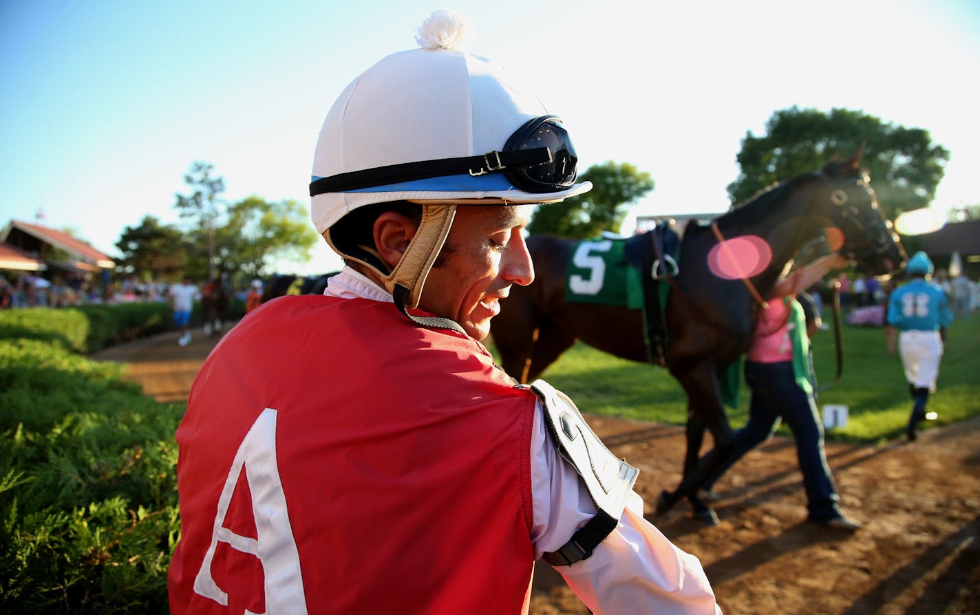 Jockey Leandro Goncalves fastened his number on his jersey before getting on Ms Dixie Girl for his second race of the day. ] (KYNDELL HARKNESS/STAR TRIBUNE) kyndell.harkness@startribune.com Following jockey Leandro Goncalves during a part of his racing day at Canterbury Park in Shakopee, Min., Thursday July 30, 2015.