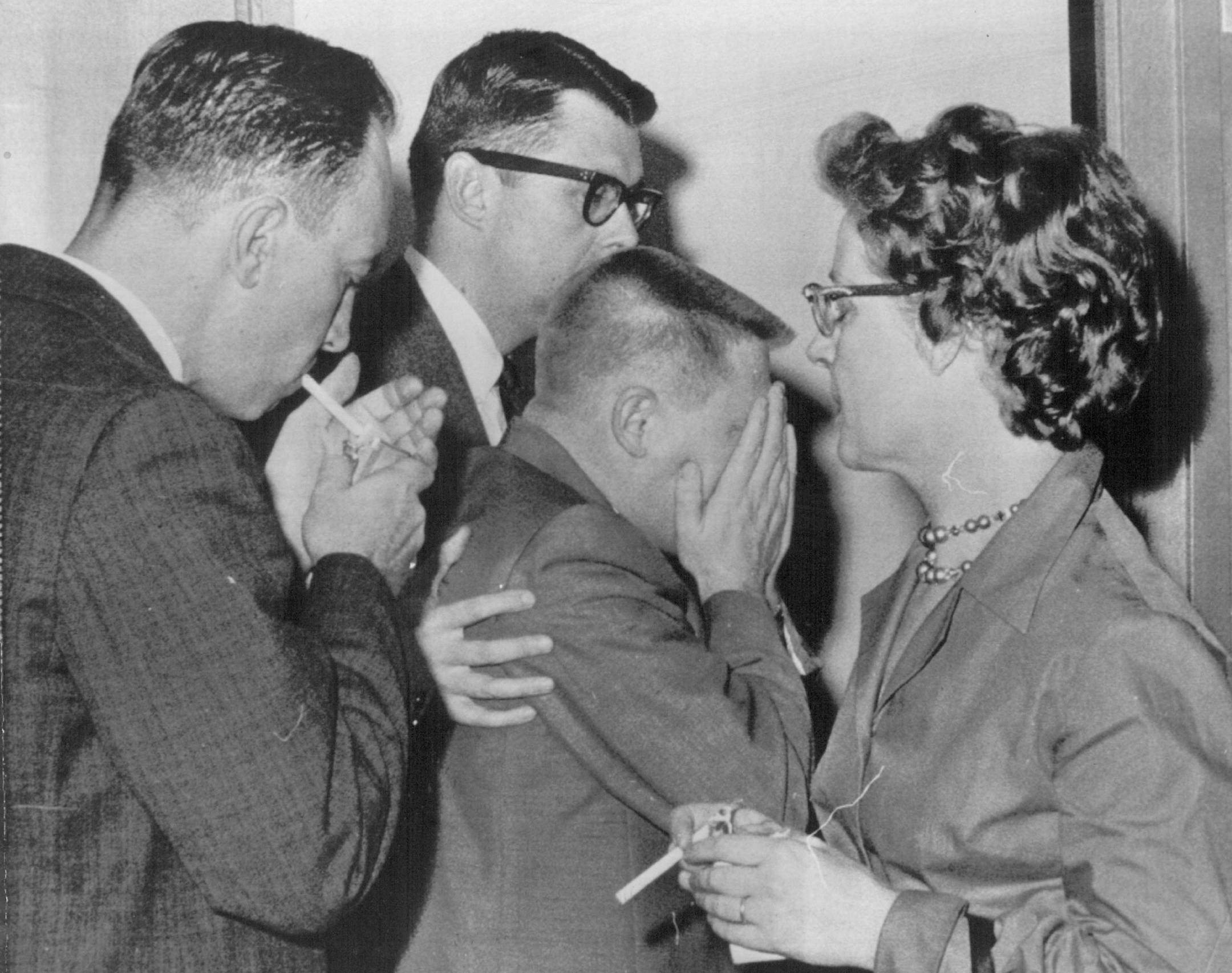 November 27, 1963 Thompson Broke Down - T. Eugene Thompson, accused of arranging his wife's murder, broke down was escorted from the courtroom Tuesday after listening to a witness describe the slaying. One of his attorneys, William Fallom (left), took him to a side room during a recess in the Minneapolis trial. The woman at right is Mrs. Hyam Segell, wife of one of Thompson's attorneys. Associated Press