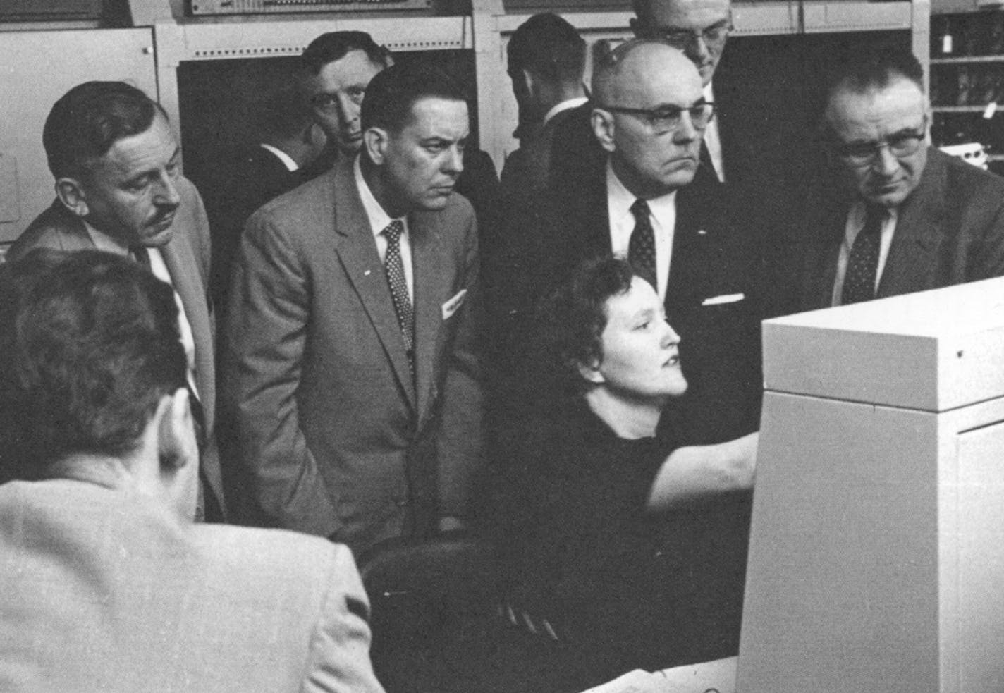 Irma Wyman demonstrates the Datamatic 1000 to officials from the U.S. Treasury's punched card U. S. Savings Bond division.