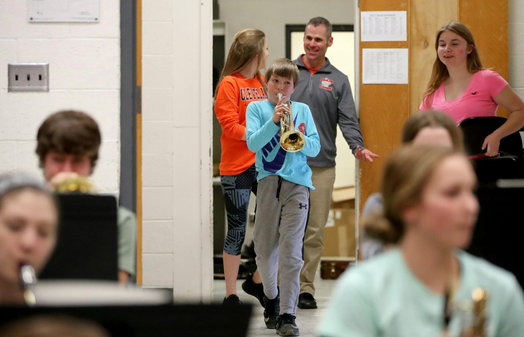 Eighth grader Aarin Clough, middle, gets a head start on trumpet work before band practice at Cleveland Public School, where almost 90 percent of the school's students play in band, Tuesday, Feb. 21, 20117, in Cleveland, MN. Band teacher Erik Hermanson talks with students to Clough's rear.