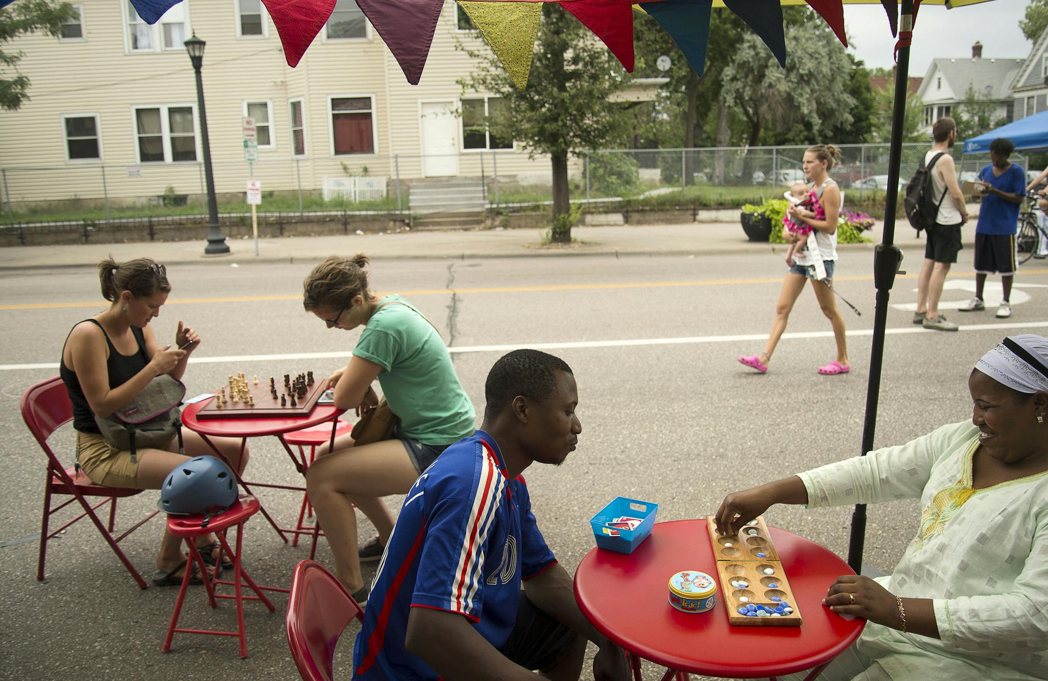 From left, Amy Jones, of Minneapolis, played Hannah Rossio, of Portland, Ore., in chess while Mouydine Bolarinwa played mancala with his wife Mutiatu Bolarinwa, both of Minneapolis, at the “sPARKit” pop-up park.