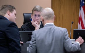 Judge R. Michael Waterman, center, listens to defense attorneys Corey Chirafisi, right, and County District Attorney Karl Anderson, left, during the N