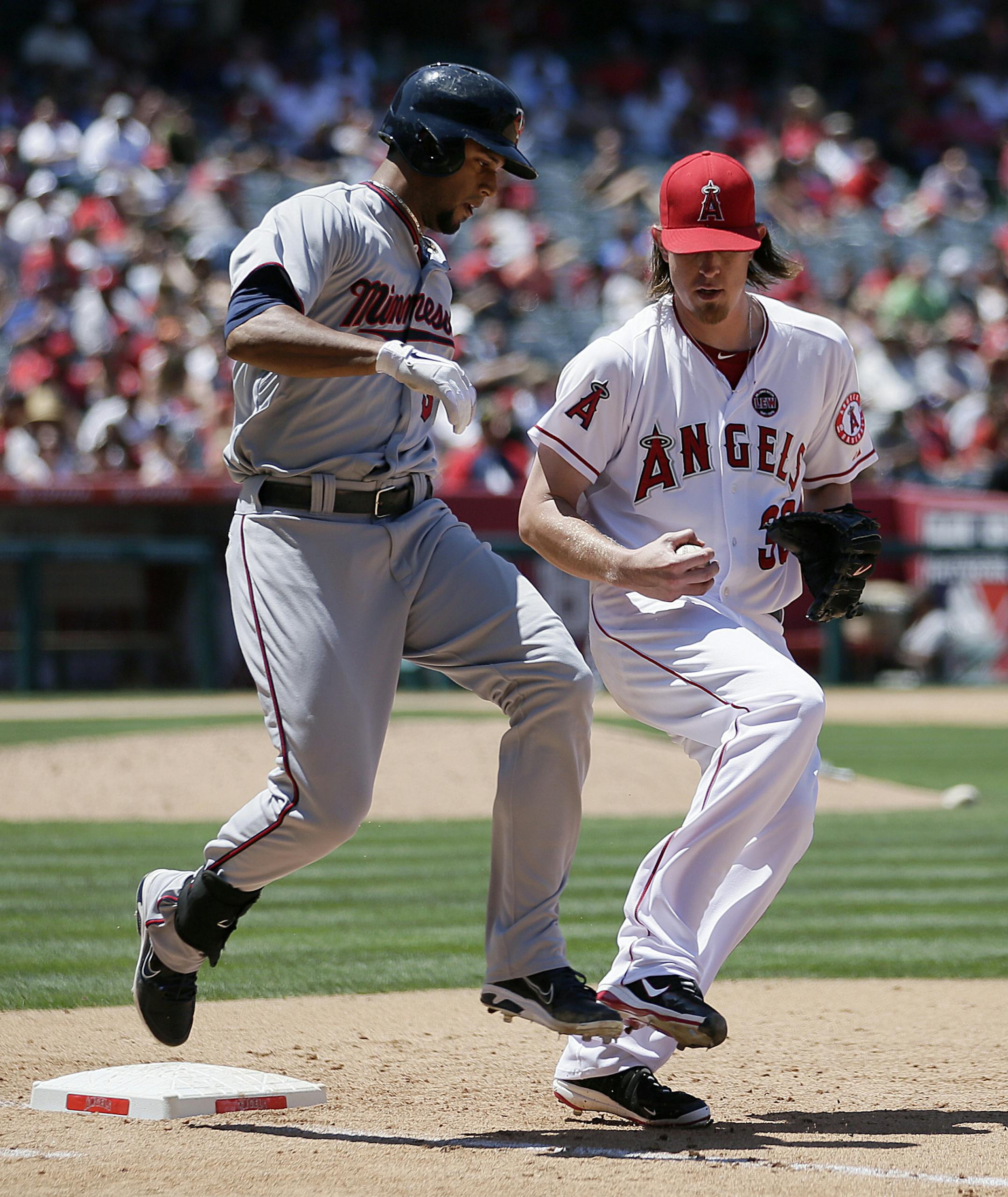 Minnesota Twins' Aaron Hicks, left, is forced out at first base by Los Angeles Angels starting pitcher Jered Weaver, right, during the sixth inning of a baseball game on Wednesday, July 24, 2013, in Anaheim, Calif. (AP Photo/Jae C. Hong)