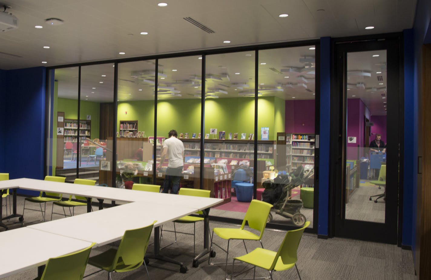 A conference room is bordered by a a children's reading area inside the Walker Library.