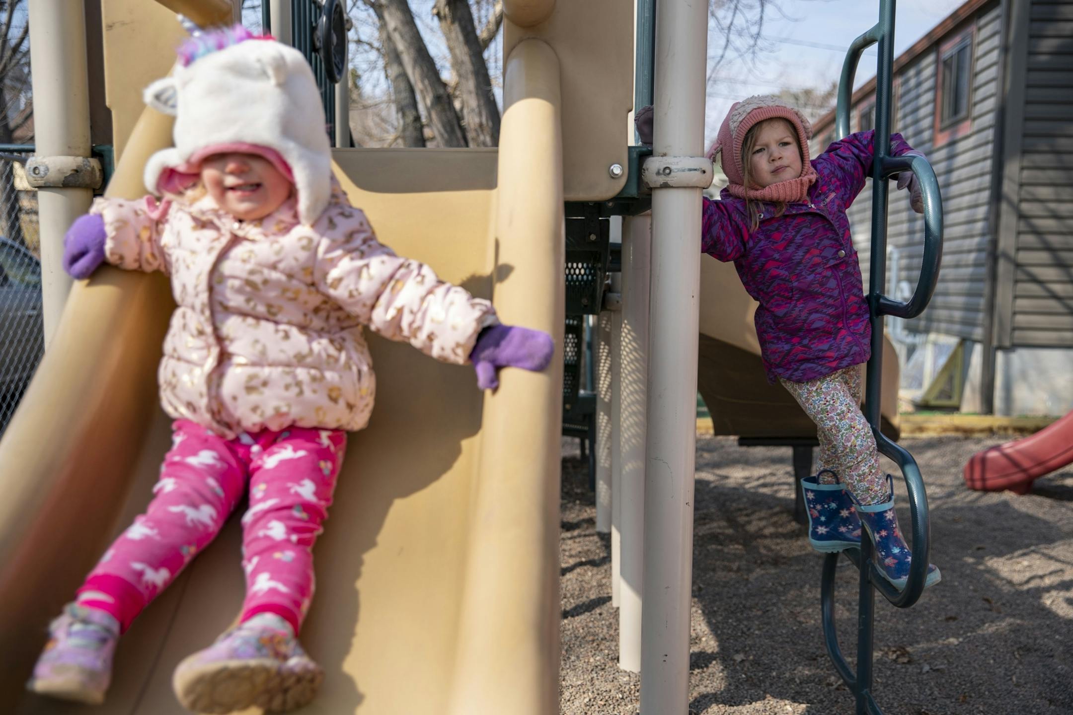 (Left) Kieran slid down a slide while Nola played on the bars on a playground at Aunty's Child Care in Duluth, MN on Thursday.