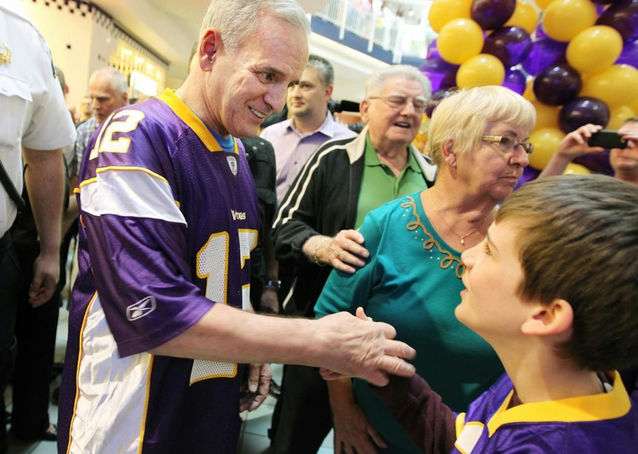Governor Mark Dayton shakes hands with Aidan Scott, 11, of Minneapolis at a rally for The Minnesota Vikings stadium at the Mall of America in Bloomington May 5, 2012.