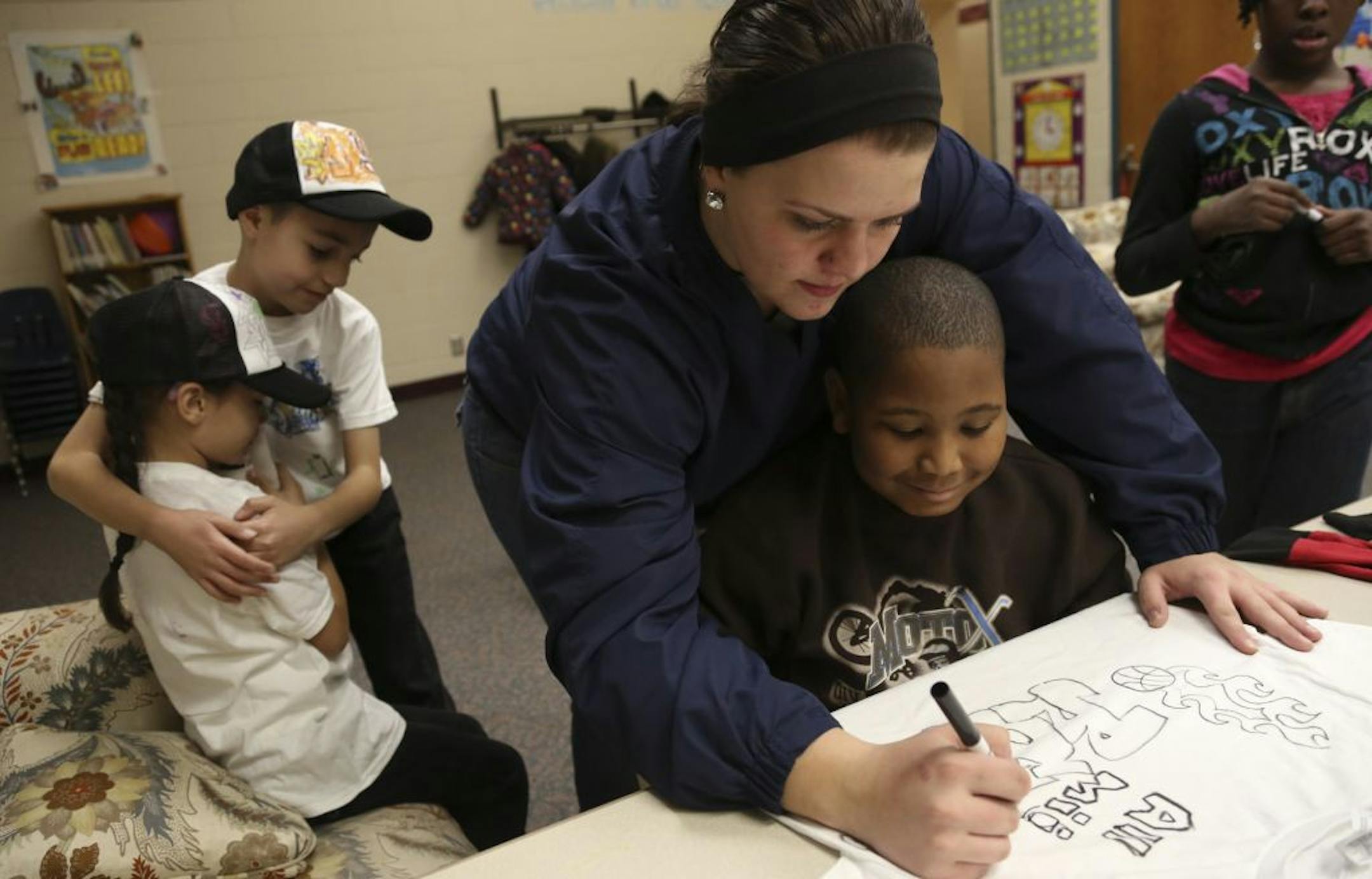 Nikki Overton, after school program director, helped Robert Johnson , 9, decorate his shirt at the Conway Recreation Center in St. Paul, Min., Wednesday November 28, 2012. The St. Paul City Council is considering a plan by the city's parks department to transfer two rec centers to nonprofits to manage.