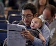 Sacramento councilman Eric Guerra, carries his son Javier as he reads through the agenda before addressing the Project Prosper Community Meeting at th
