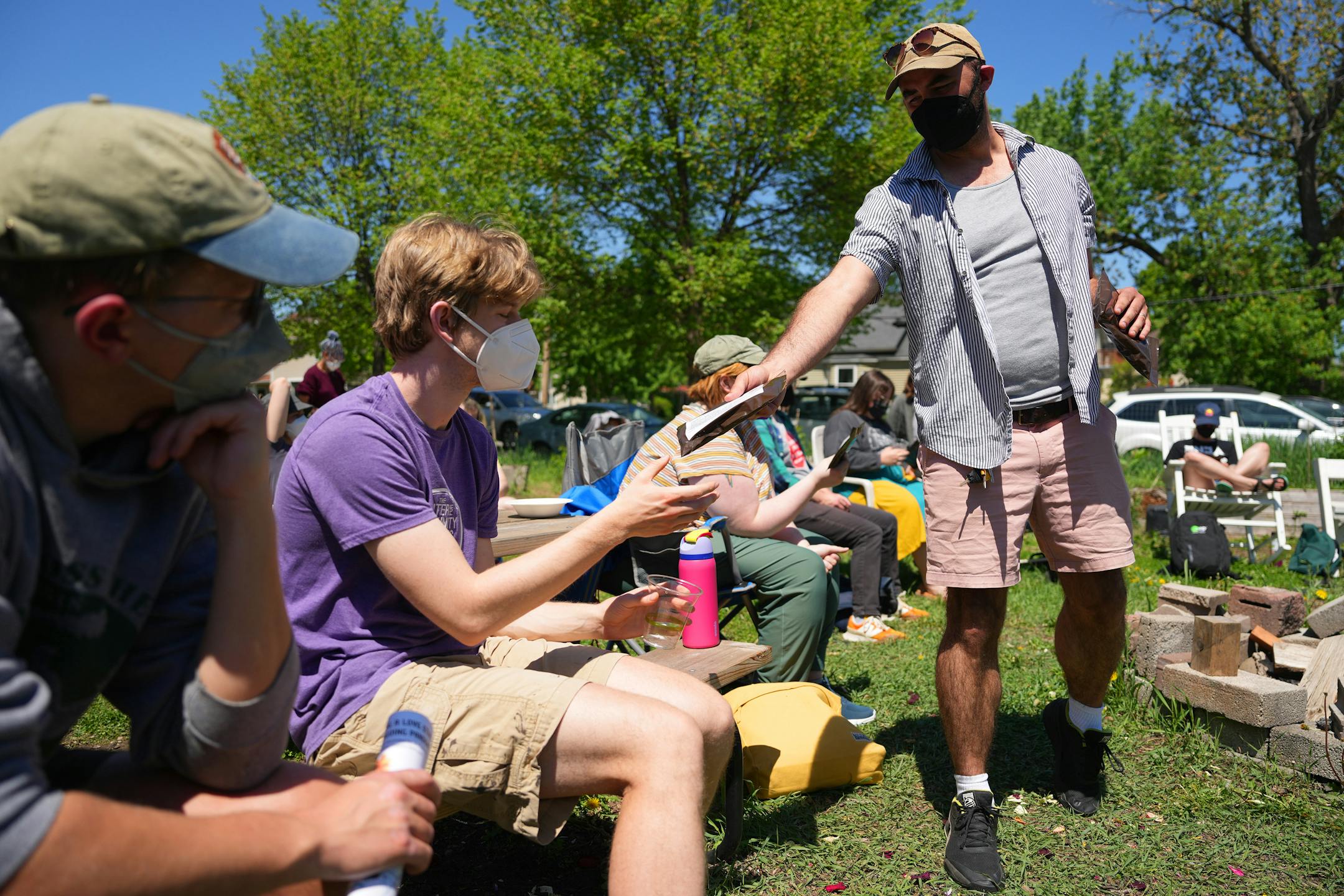 Zach Johnson, a program director with Southside Harm Reduction Services, passes out naloxone kits to community members as they gather for an overdose training session.