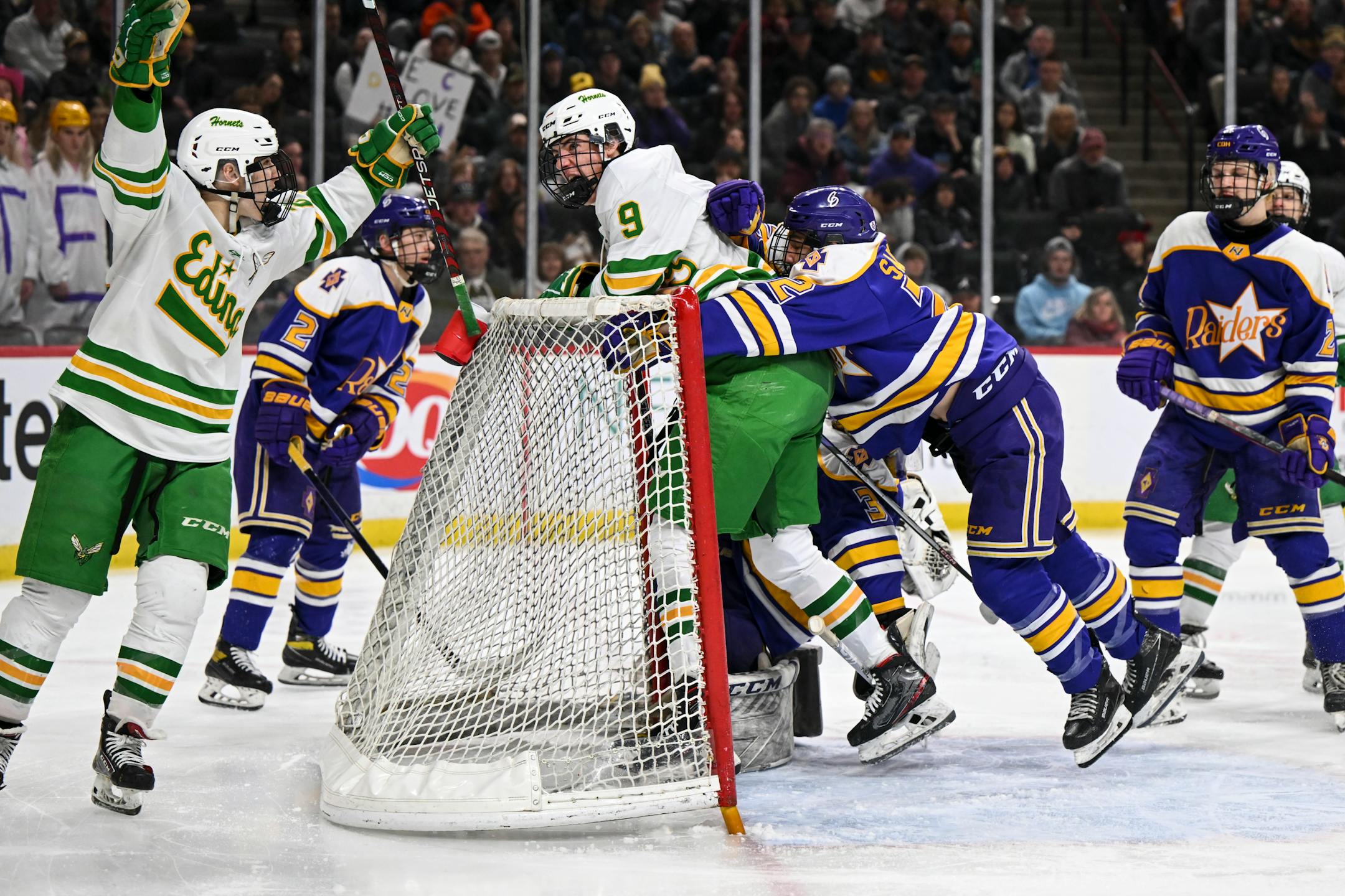 Teammates celebrate with Edina forward Mason West (9) after West scored a goal against Cretin-Derham Hall goaltender Leo Miller (35) during the second period.