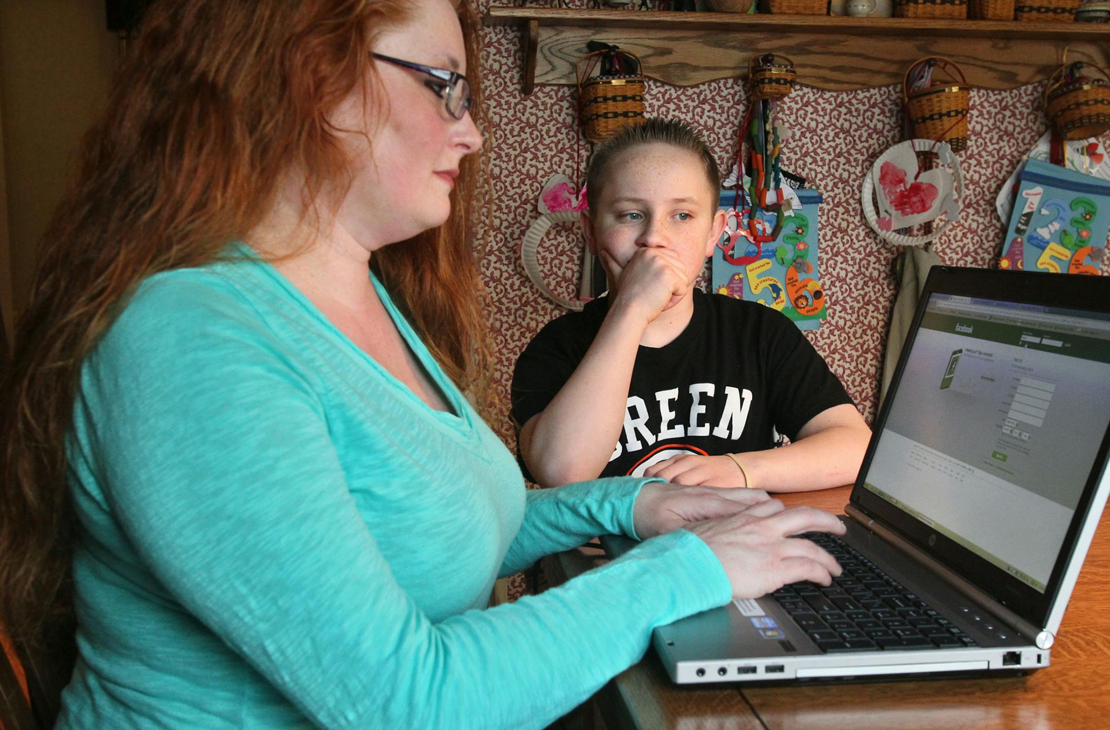 Amanda Krebs, left, uses the password that only she knows to sign on her son, Korey, to his Facebook page at their home, March 5, 2013, in Green, Ohio. According to a new study by the Education Database Online, half of the parents who have a Facebook page say they have started one to keep tabs on their children. (Ed Suba Jr./Akron Beacon Journal/MCT) ORG XMIT: 1137730 ORG XMIT: MIN1304231109530198
