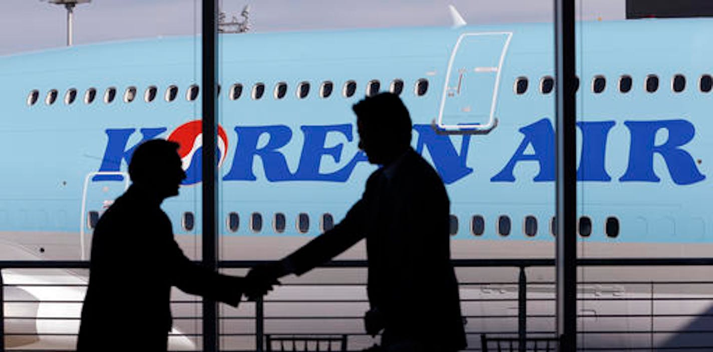 FILE - In this Tuesday, Aug. 25, 2015, file photo, Ray Conner, left, Boeing president and CEO of commercial airlines, shakes hands with Walter Cho, Korean Air's executive vice president and chief marketing officer, during a ceremony in view of a new Boeing 747-8 Intercontinental jet that Korean Air took delivery of in Everett, Wash. Delta Air Lines and Korean Air are taking steps to mend a chilly relationship, announcing an expansion of their partnership Wednesday, Sept. 7, 2016, where each airl