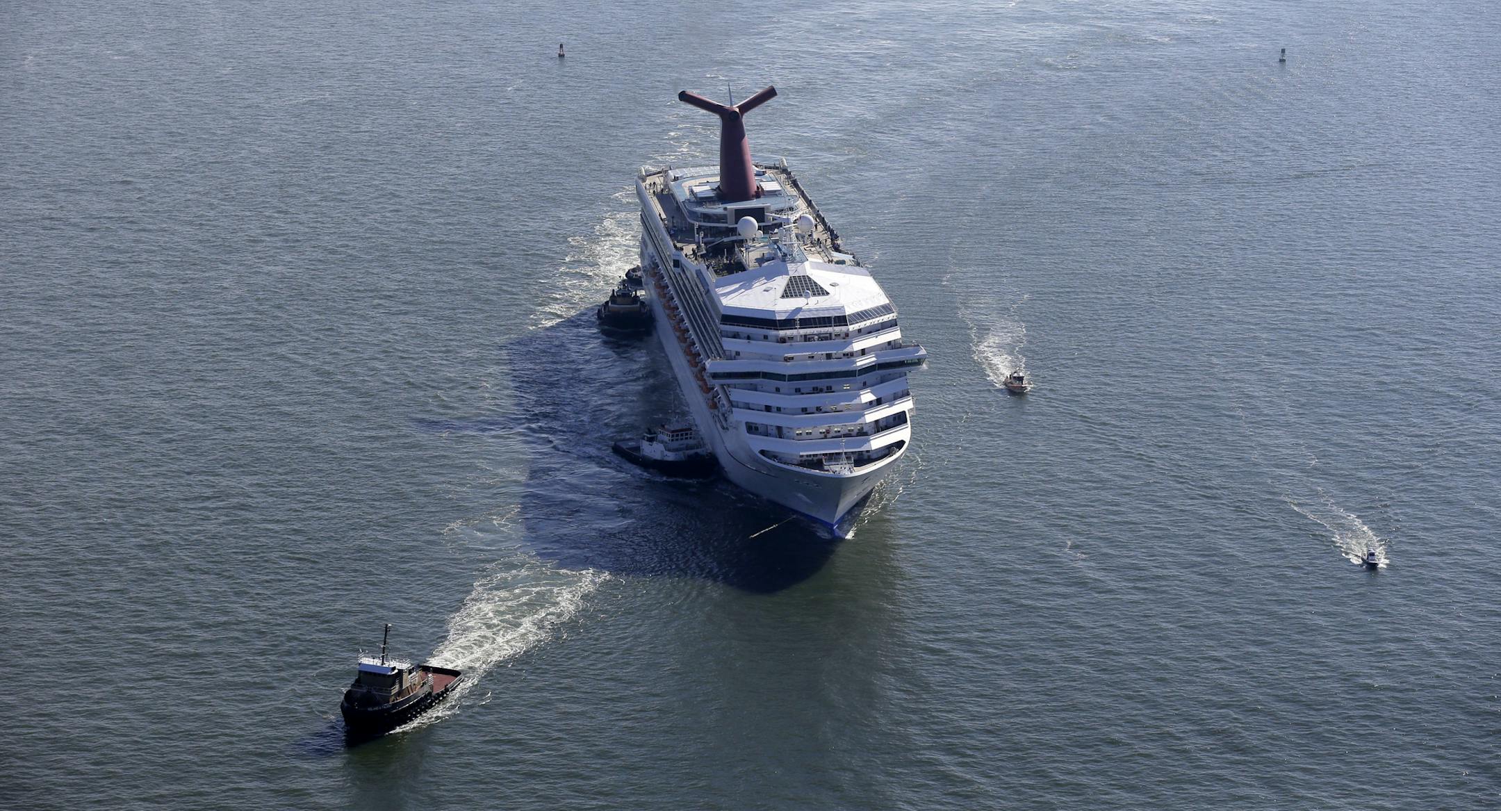 FILE - This Feb. 14, 2013 file photo shows the disabled Carnival Lines cruise ship Triumph being towed to harbor off Mobile Bay, Ala. Carnival Cruise Lines on Wednesday, April 17, announced a $300 million program to add emergency generators, upgrade fire safety and improve engine rooms on all 24 of its ships. The announcement could help the brand begin rebounding from a wave of bad publicity that began in February, when an engine fire knocked out power on the Carnival Triumph. (AP Photo/Gerald H