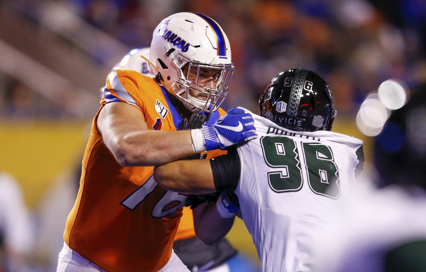 Boise State offensive lineman Ezra Cleveland, left, battles against Hawaii defensive lineman Kaimana Padello