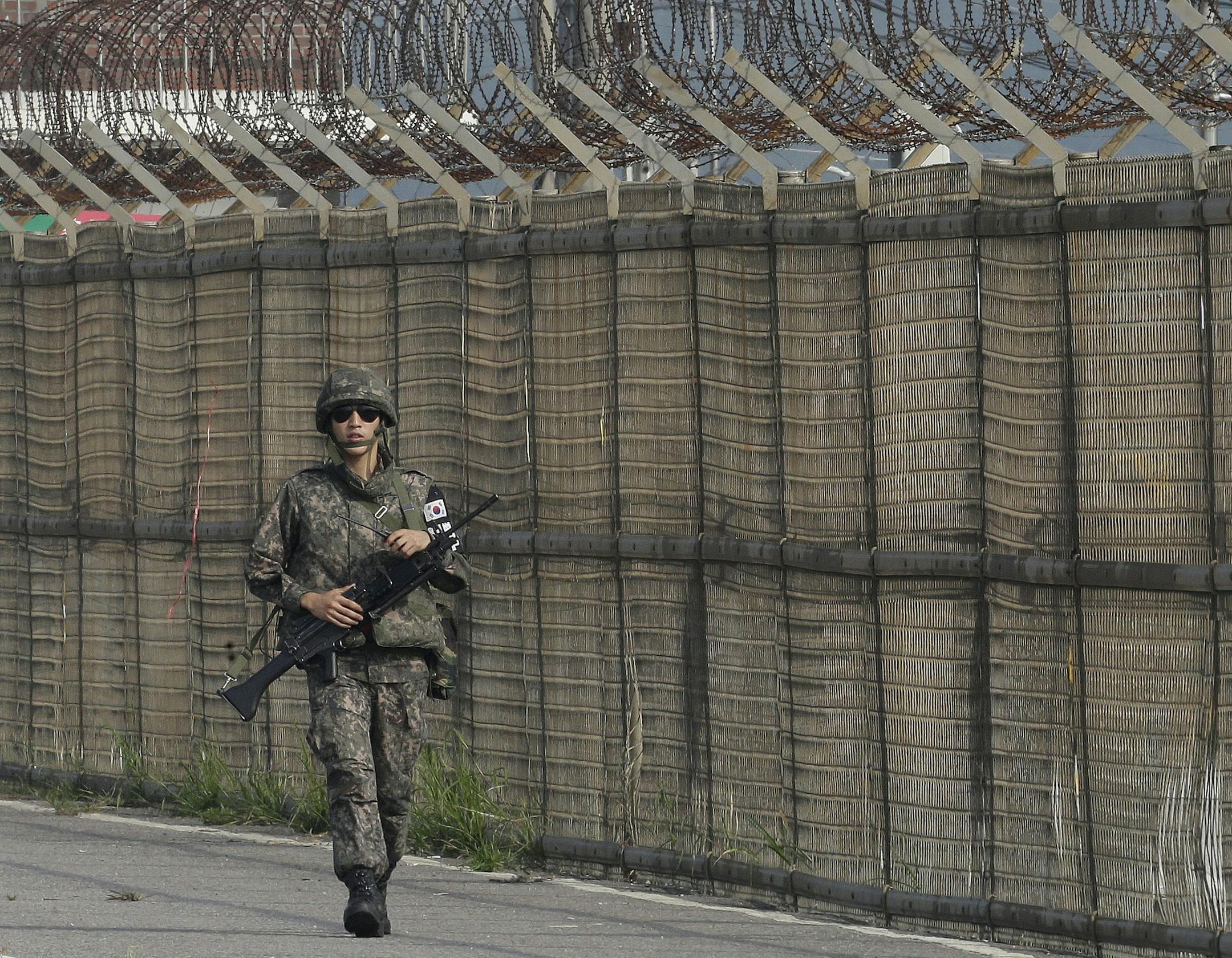 File - In this Saturday, Aug. 22, 2015 file photo, a South Korean army soldier walks along the military wire fences on Unification Bridge, which leads to the demilitarized zone, near the border village of Panmunjom in Paju, South Korea. The Demilitarized Zone, a Cold War vestige, was created as a buffer zone in 1953 after the three-year Korean War, which ended with an armistice. That armistice has yet to be replaced with a peace treaty, leaving the Korean Peninsula in a technical state of war. A