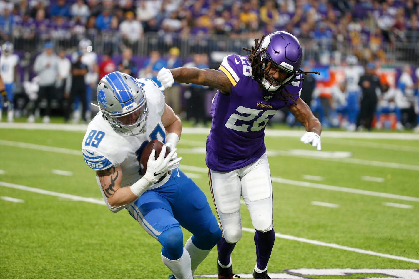 Lions tight end Isaac Nauta is tackled by Vikings cornerback Trae Waynes