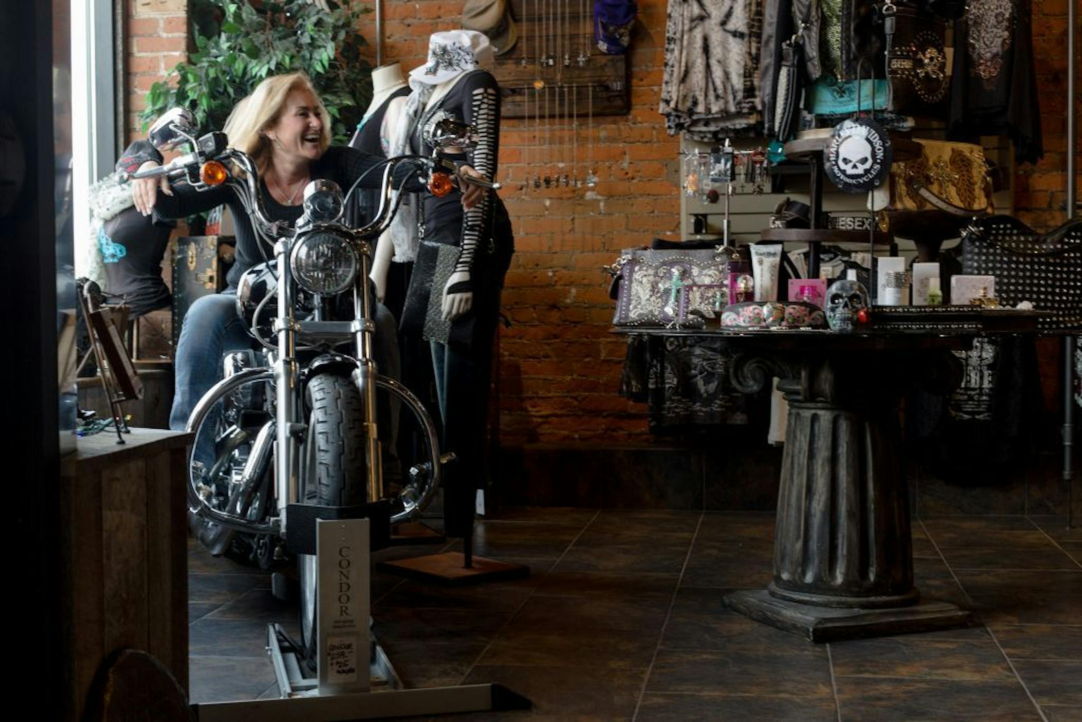 Inessa Hansen, founder and designer of OneSexyBikeChick, poses on the store front's motorcycle Friday afternoon.