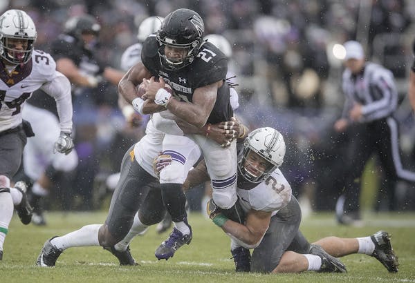 Minnesota's defensive backs Duke McGhee, left, and Jacob Huff, right, couldn't stop Northwestern's running back Justin Jackson during the first quarte