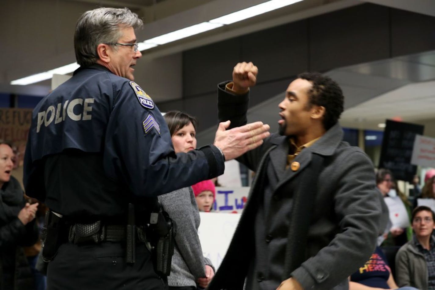 James Badue, who is with the Minnesota NAACP, led protesters in a chant: "No hate, no fear, immigrants are welcome here," as an airport police officer tried to quiet him Saturday at Minneapolis-St. Paul Airport. Protesters were responding to an executive order signed by President Donald Trump, restricting immigration from several Muslim-majority nations.