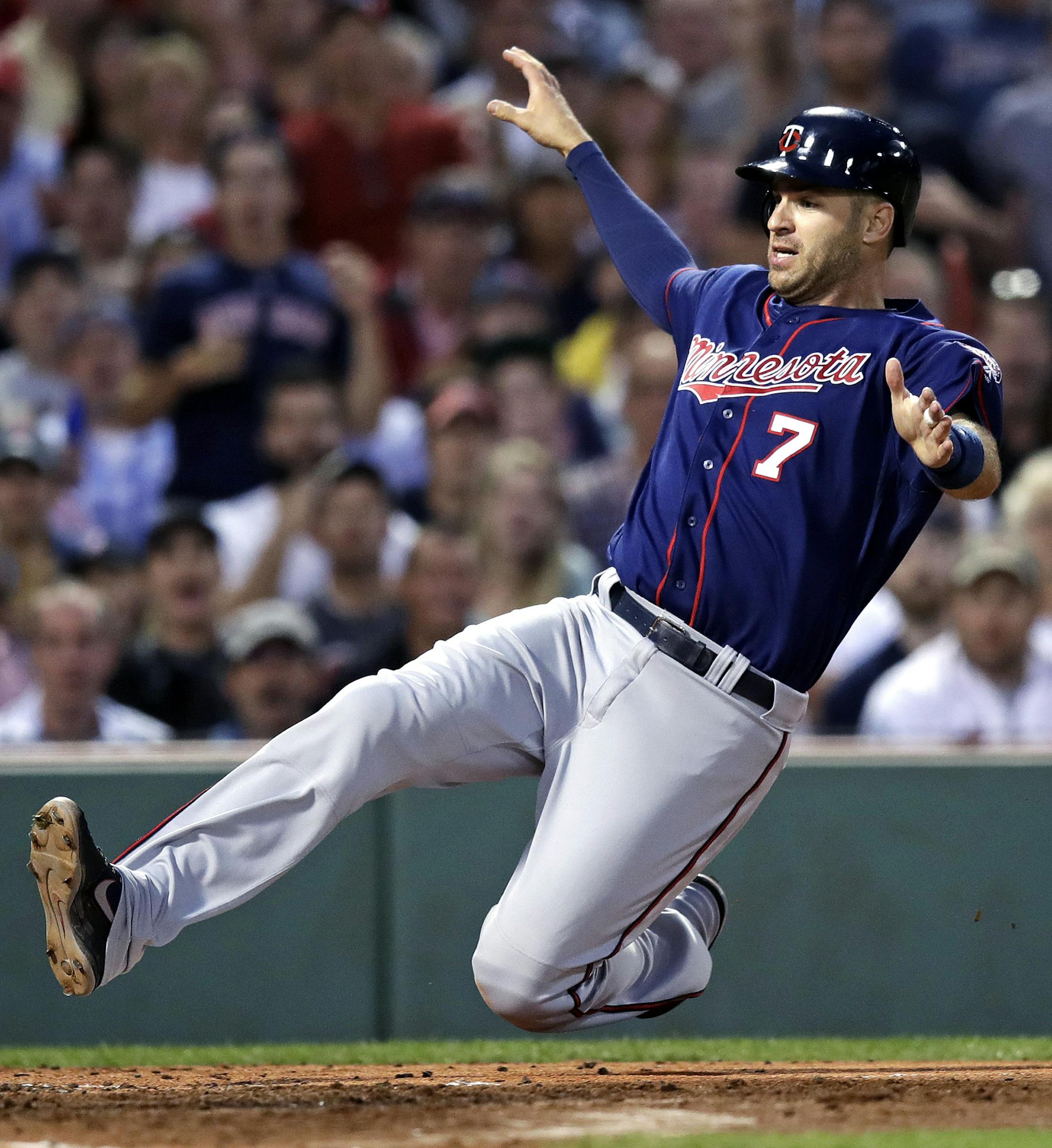 Minnesota Twins' Joe Mauer starts to slide as he scores on a double by Jorge Polanco during the fourth inning of the team's baseball game against the Boston Red Sox at Fenway Park in Boston, Thursday, June 29, 2017. (AP Photo/Charles Krupa) ORG XMIT: MIN2017071017172024